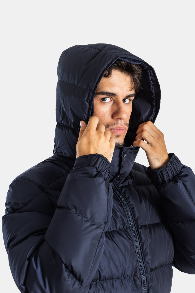 Close-up of a man adjusting his Moncler Maya quilted matte navy hood, featuring expressive hands and face.