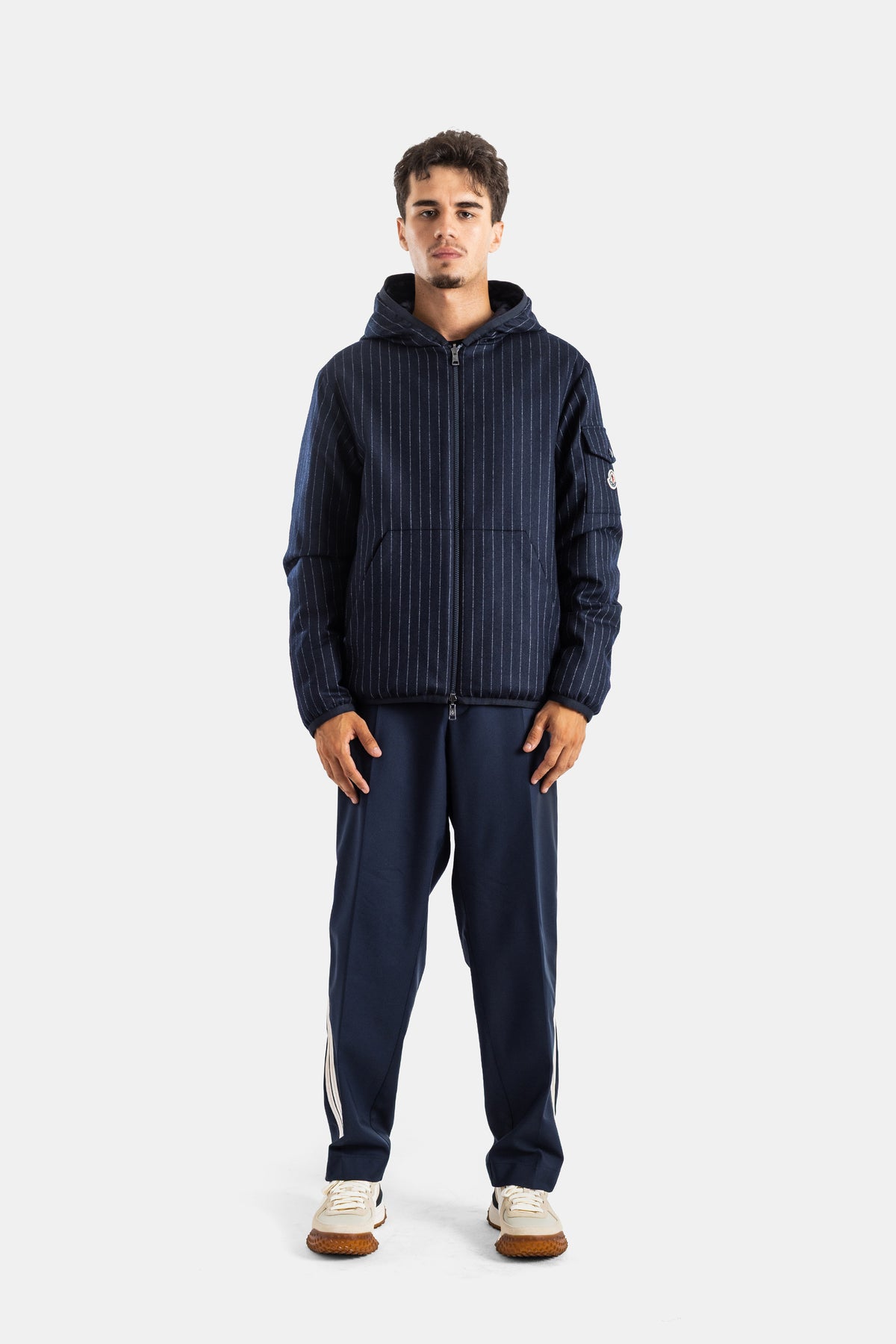 Moncler Ceze men's total navy look with white-striped trousers, adidas sneakers and sleeve logo patch.
