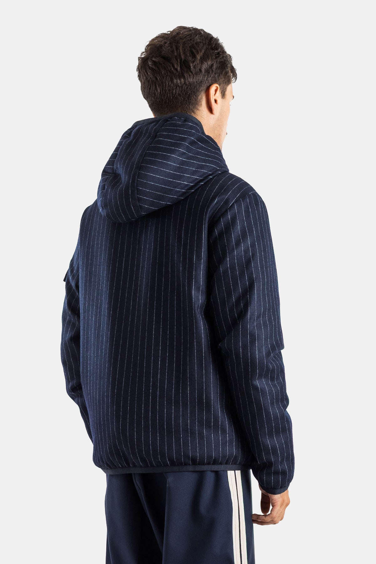 Moncler Ceze men's reversible down jacket in a back view showing navy pinstripe and structured hood.