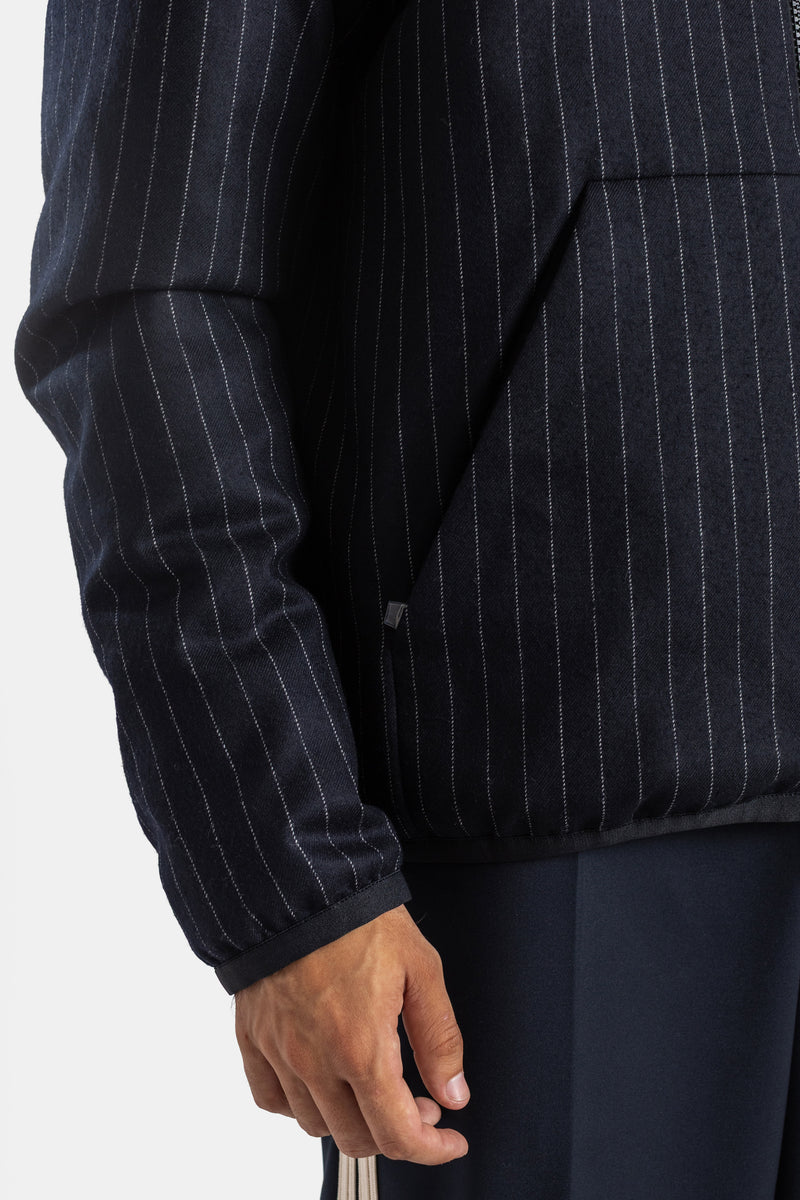 Moncler Ceze men's down jacket sleeve detail with navy pinstripe fabric and zipped side cargo pocket.