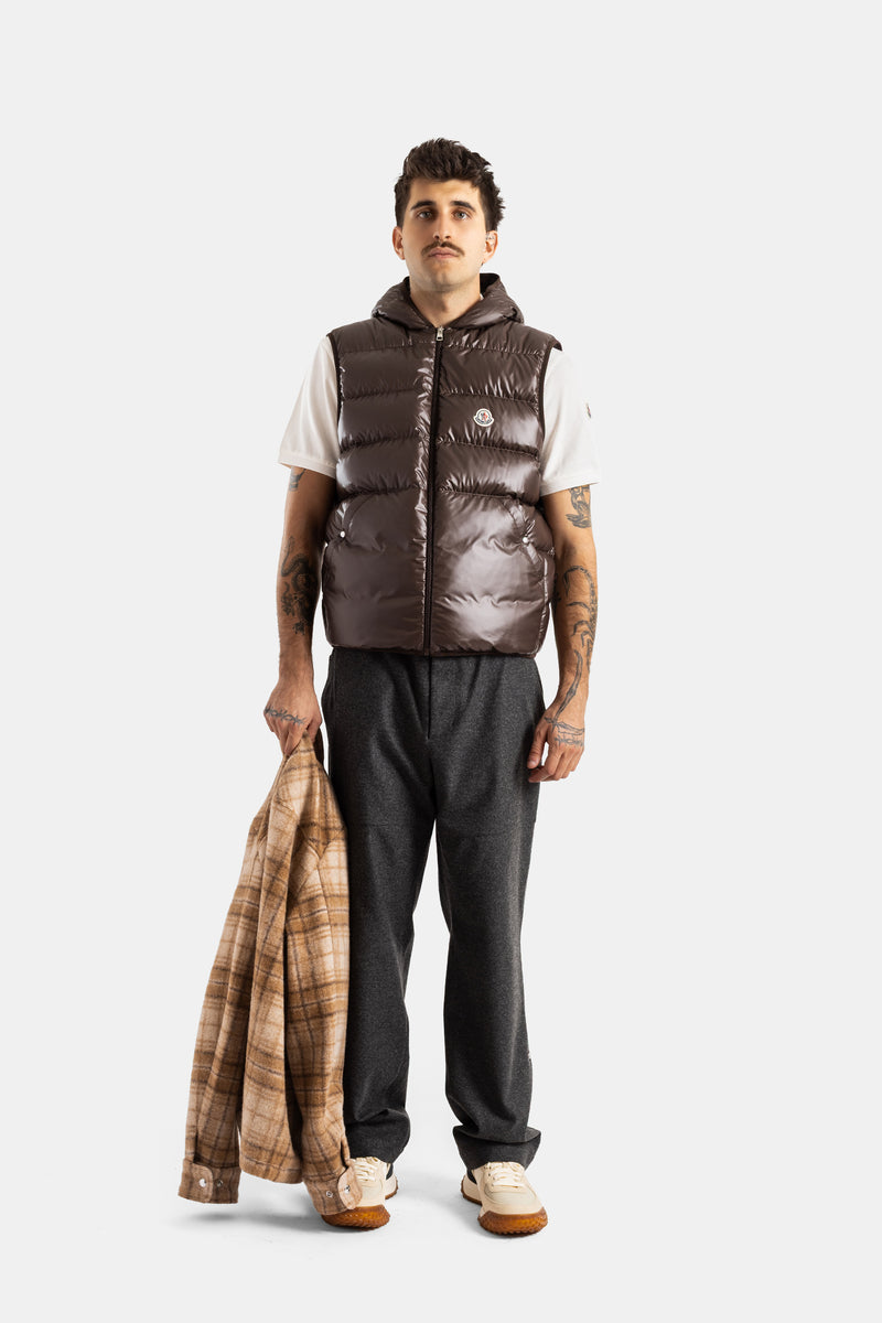 Moncler Nyvalin homme vue frontale gilet doudoune brillant brun avec tatouages bras et surchemise carreaux tenue