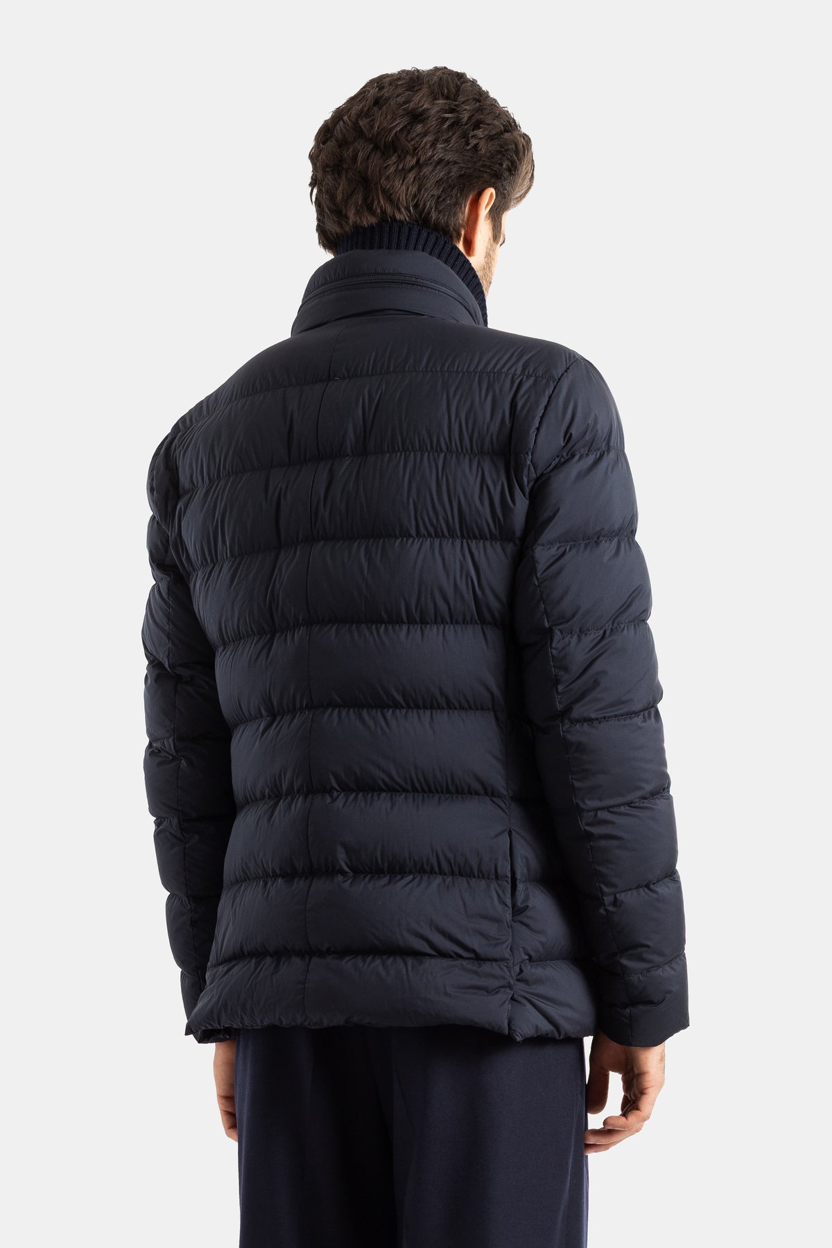 Moncler Elarune men's down jacket back view with horizontal quilting, navy blue stitching, knit collar.