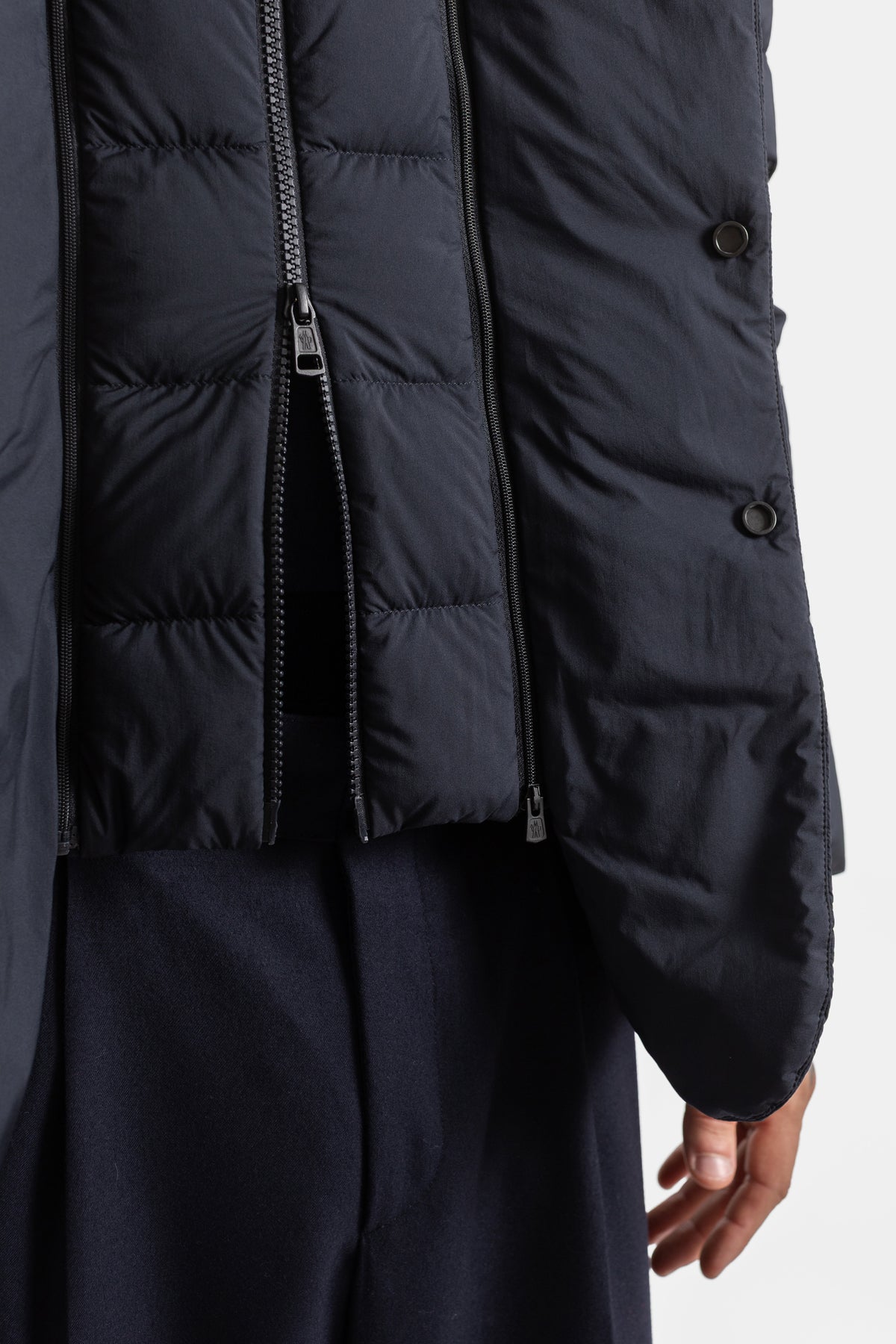Moncler Elarune men's navy blue down jacket detail featuring two-way zipper closure and snap buttons.