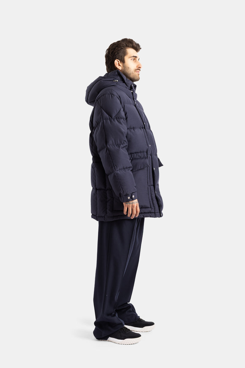 Moncler Sylmara side view of men's long down jacket in navy blue with generous hood and geometric quilting