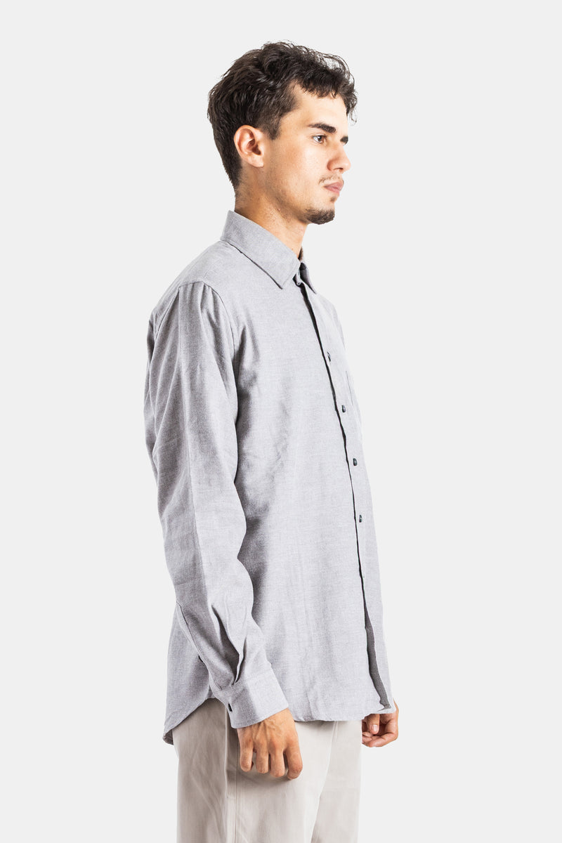 Profile view of the Sease men's grey flannel shirt featuring a relaxed cut and contrasting black buttons.