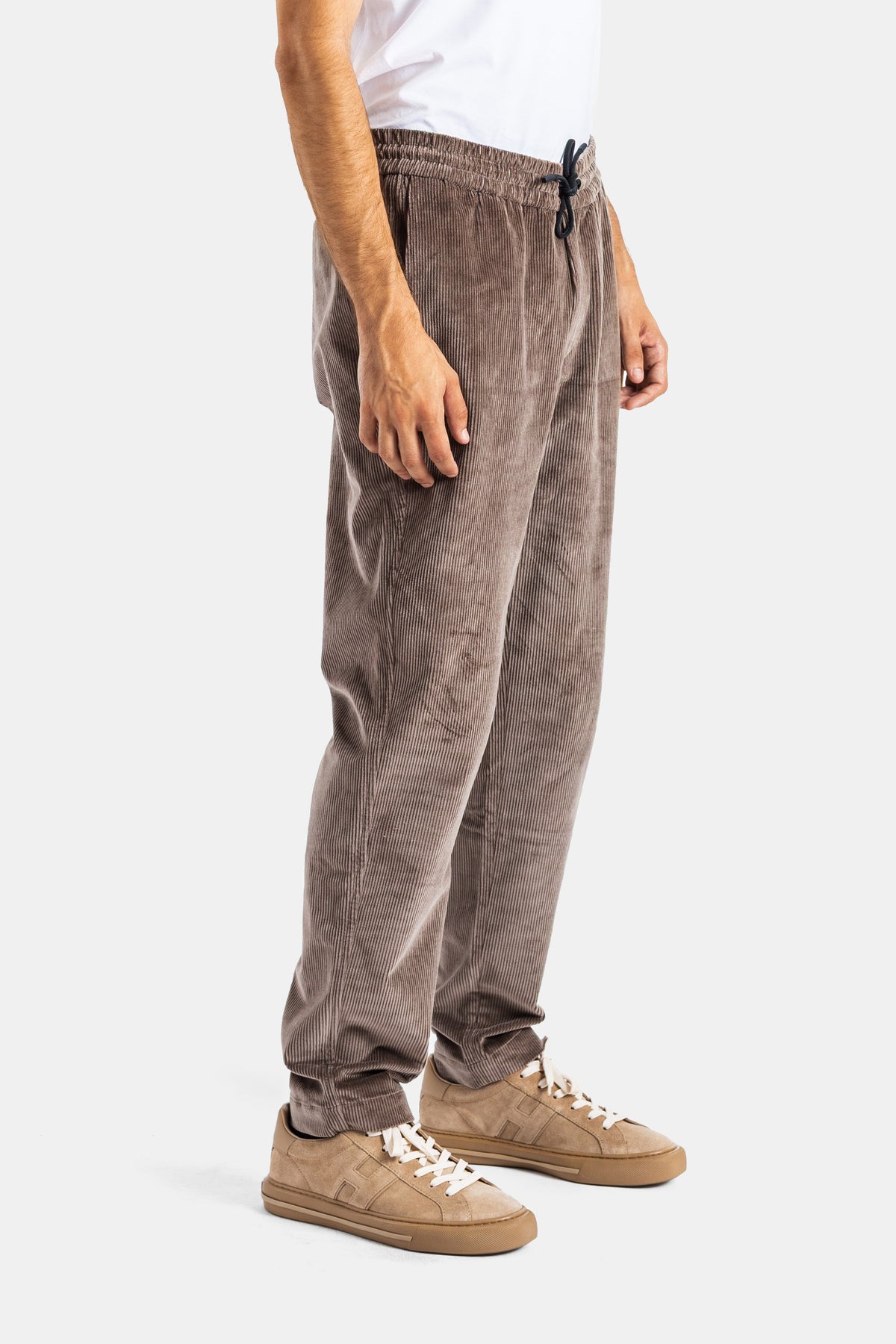 Sease Mindset taupe corduroy trousers in a side view featuring a drawstring waist and beige sneakers