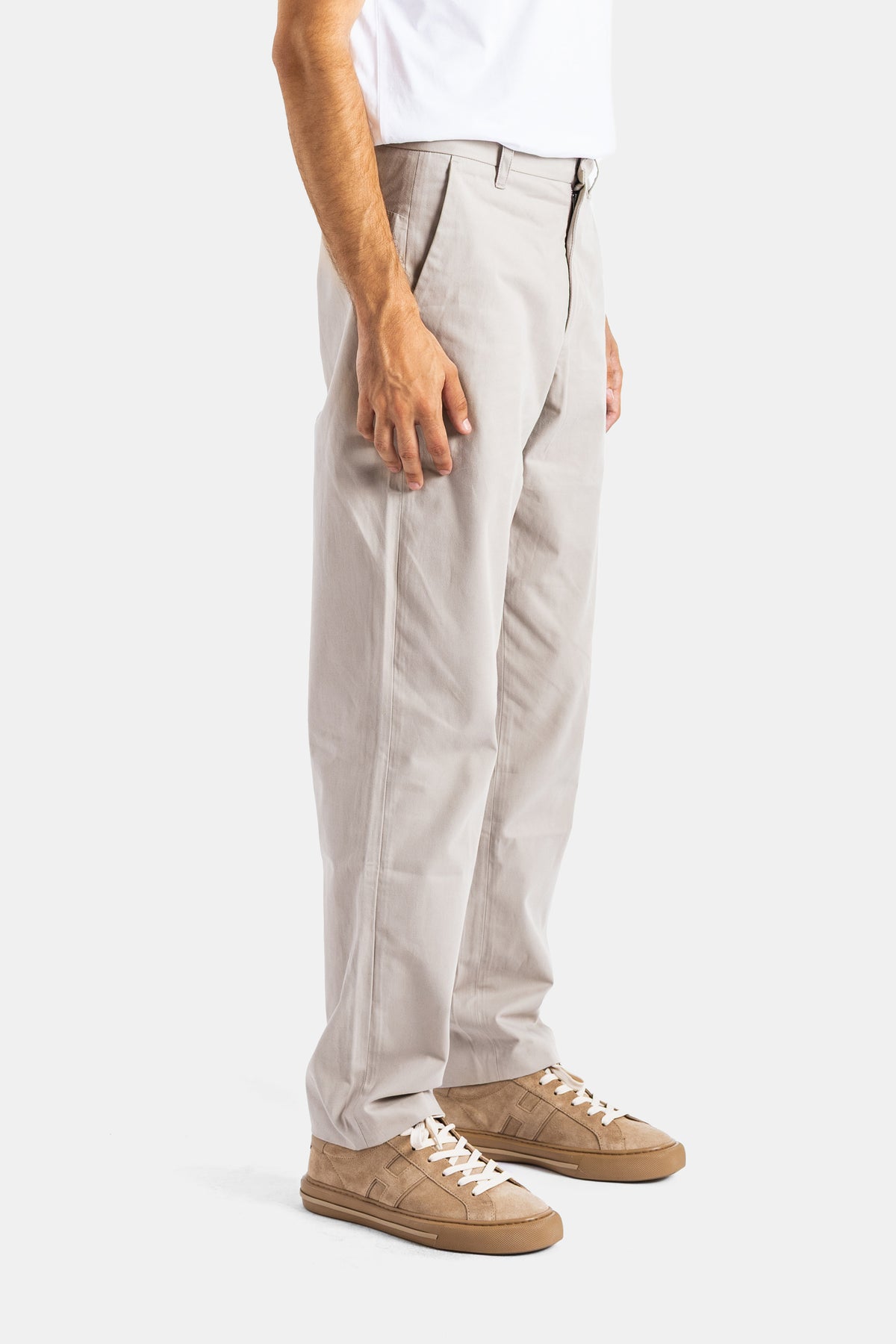 Sease chino herenbroek in zijaanzicht met hoge taille, plooi aan de voorkant en beige suède sneakers