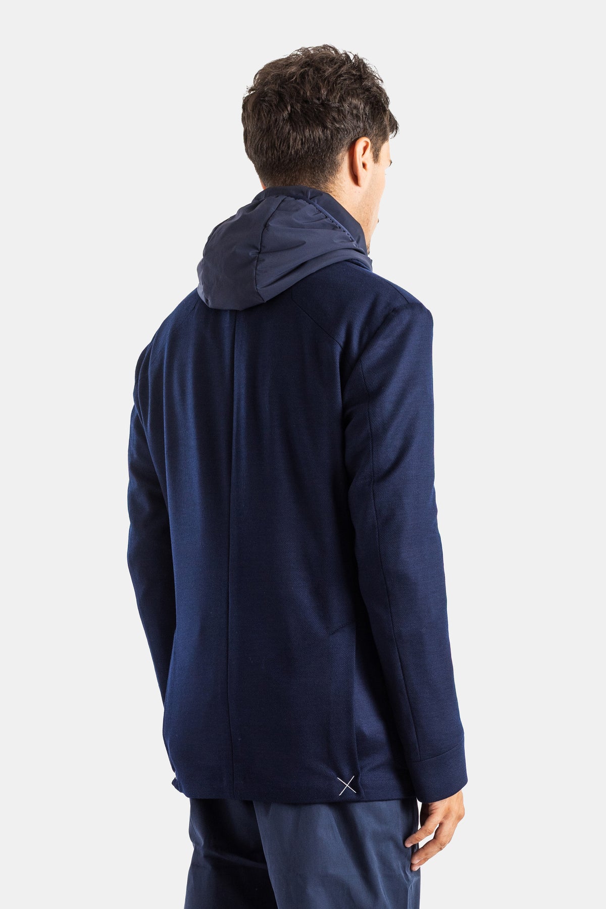 Rear view of Sease men's navy hybrid blazer, showing the contrasting nylon hood and technical raglan seams.