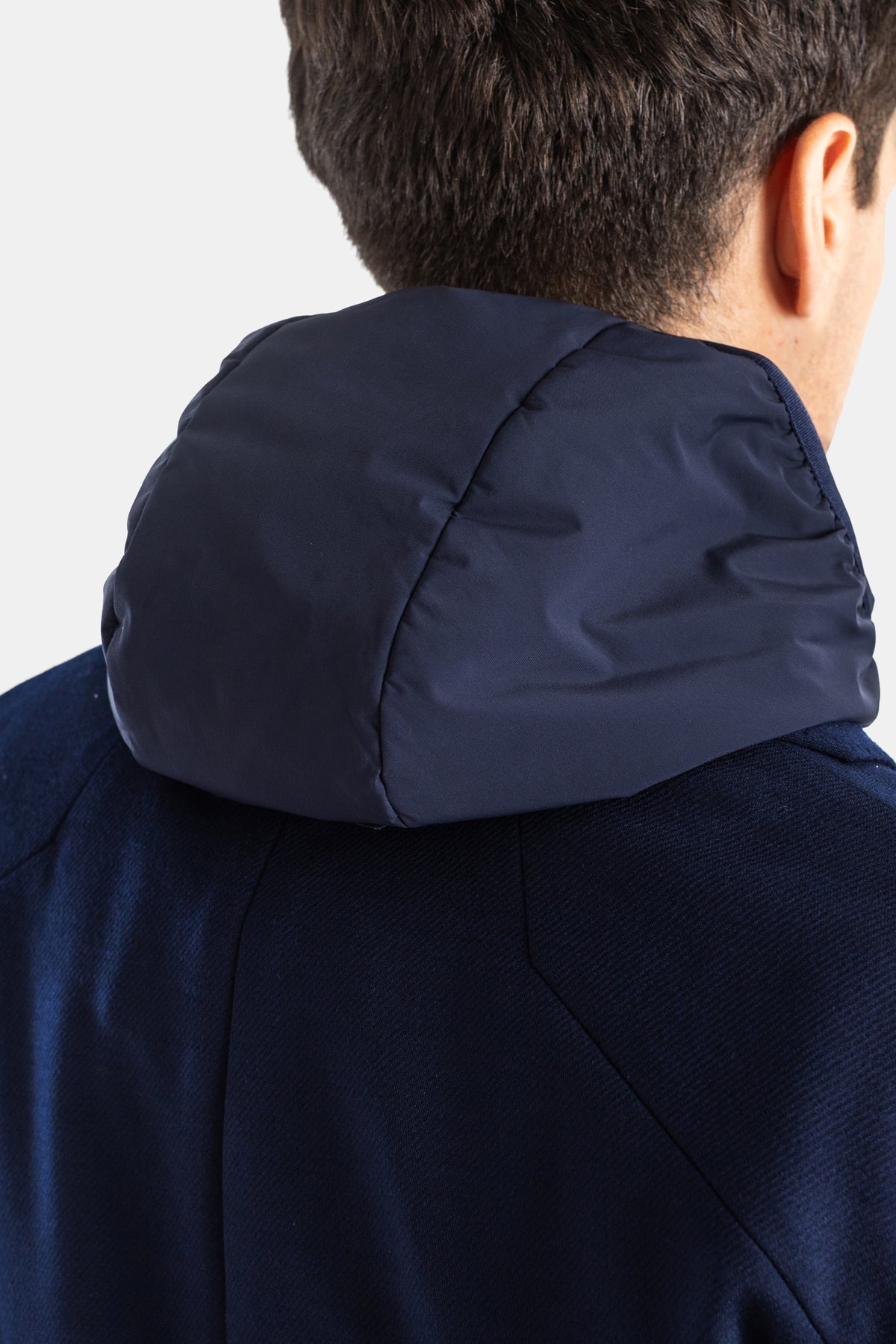 Close-up of Sease men's blazer with navy nylon quilted hood, topstitching and navy blue jersey stand-up collar.