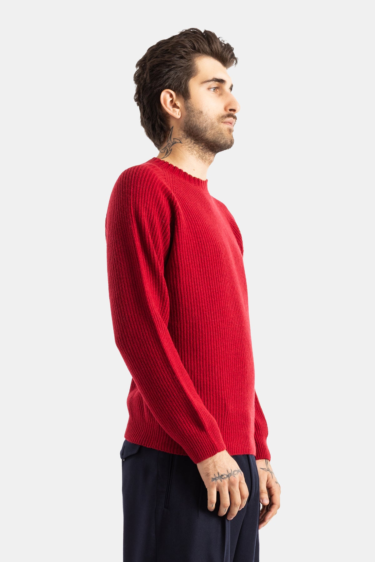 Smedley pull homme rouge côtelé vue profil, manches longues ajustées et tatouages visibles