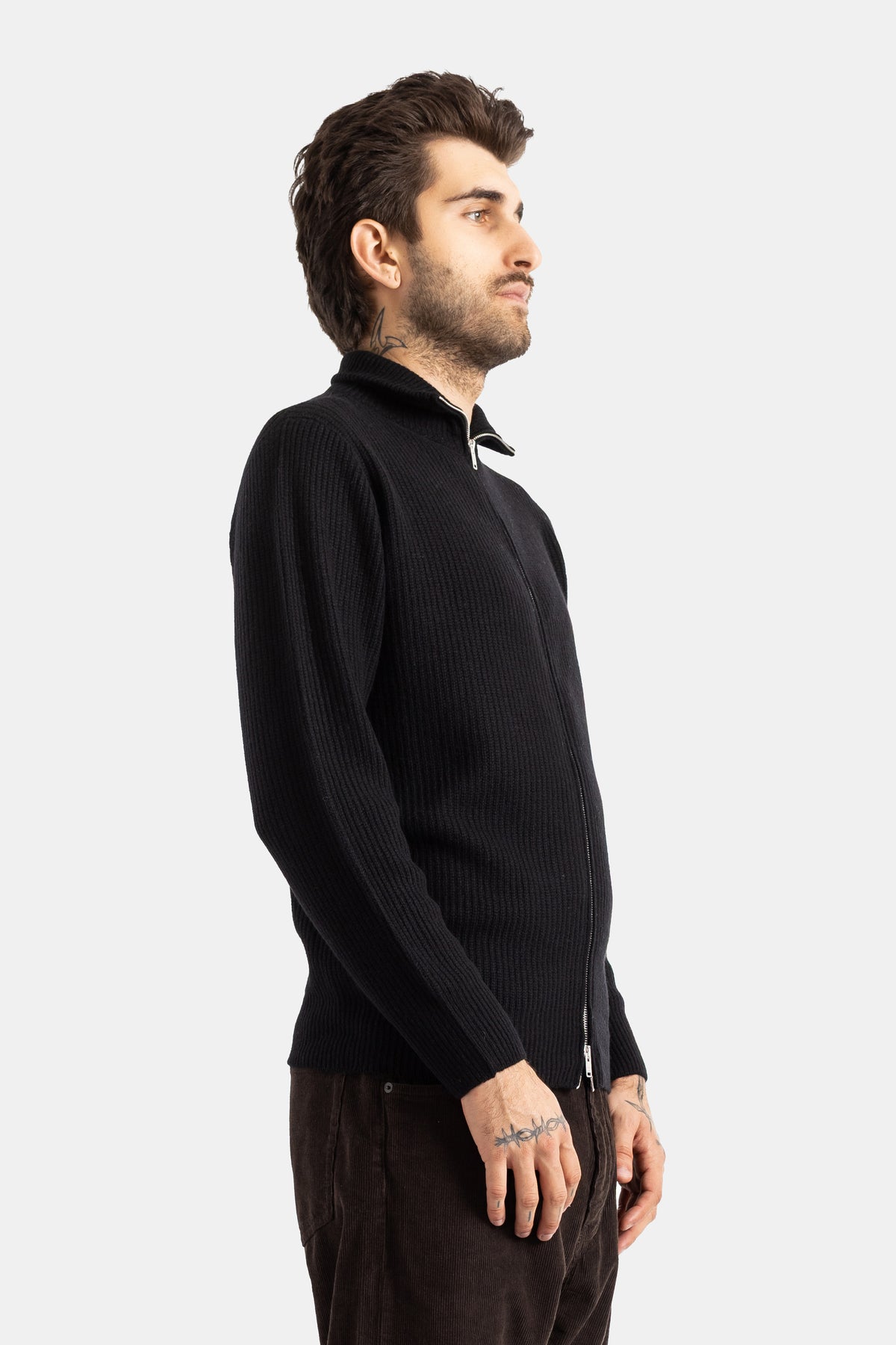 Smedley cardigan Mallam côte nervurée noire, vue profil gauche, fermeture zippée et tatouages visibles