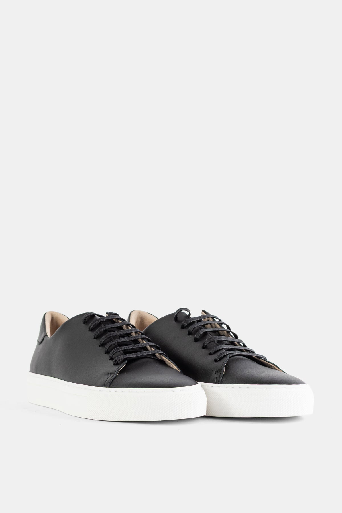 Brightway paire de sneakers cuir noir mat vue de face semelle blanche épaisse surpiqûres visibles femme SS26