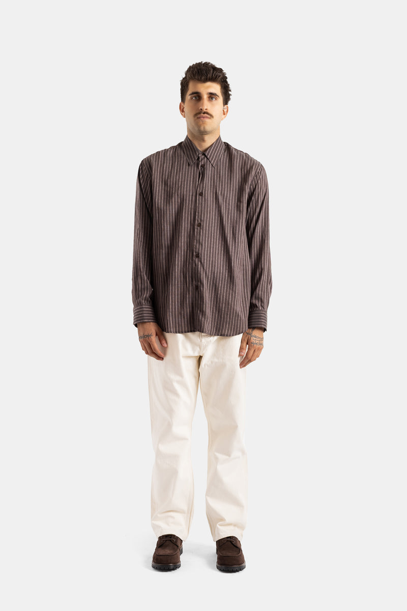 Studio Nicholson View shirt worn in a complete look with straight cream trousers and brown suede shoes