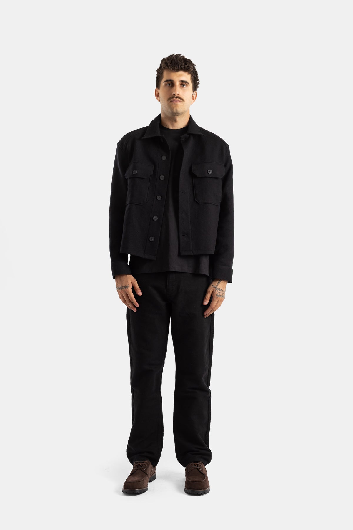 Studio Nicholson Kelver total black men look with short wool jacket worn open over t-shirt and straight pants