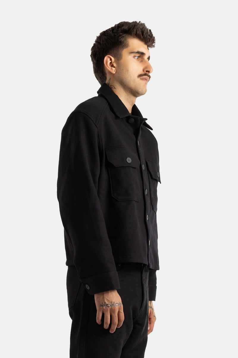 Side profile of the Studio Nicholson Kelver cropped black wool shirt-jacket with central buttons for men