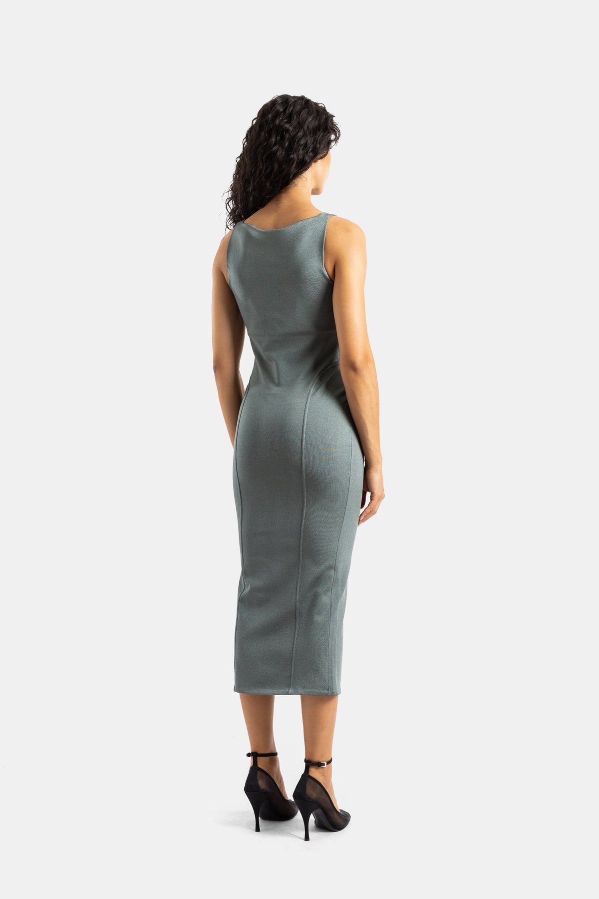 Maison Alaïa backless grey-green fitted knit midi dress with vertical structural seams and black pumps
