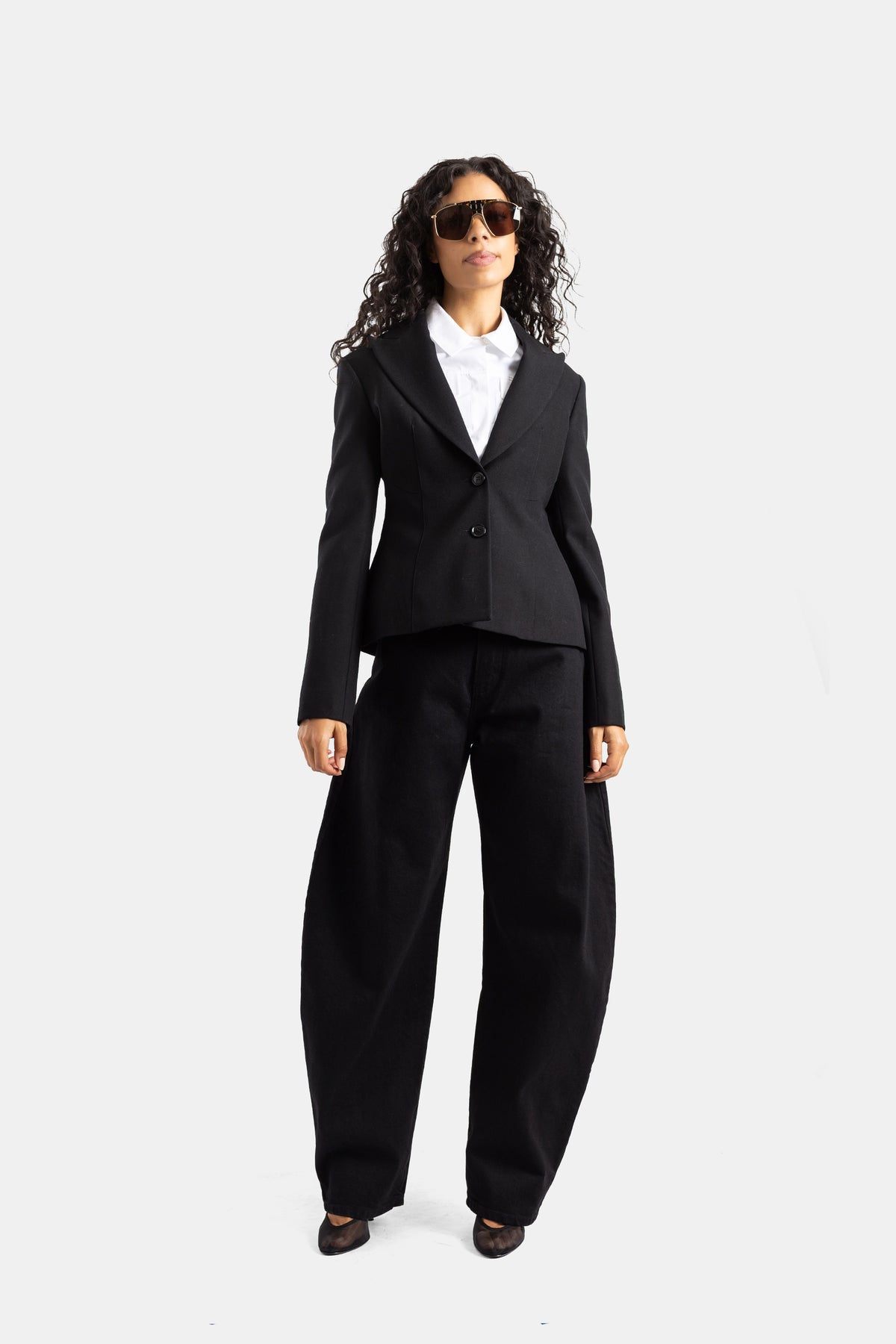 Completo sartoriale da donna Maison Alaïa in lana nera look total black con giacca strutturata e pantalone palazzo
