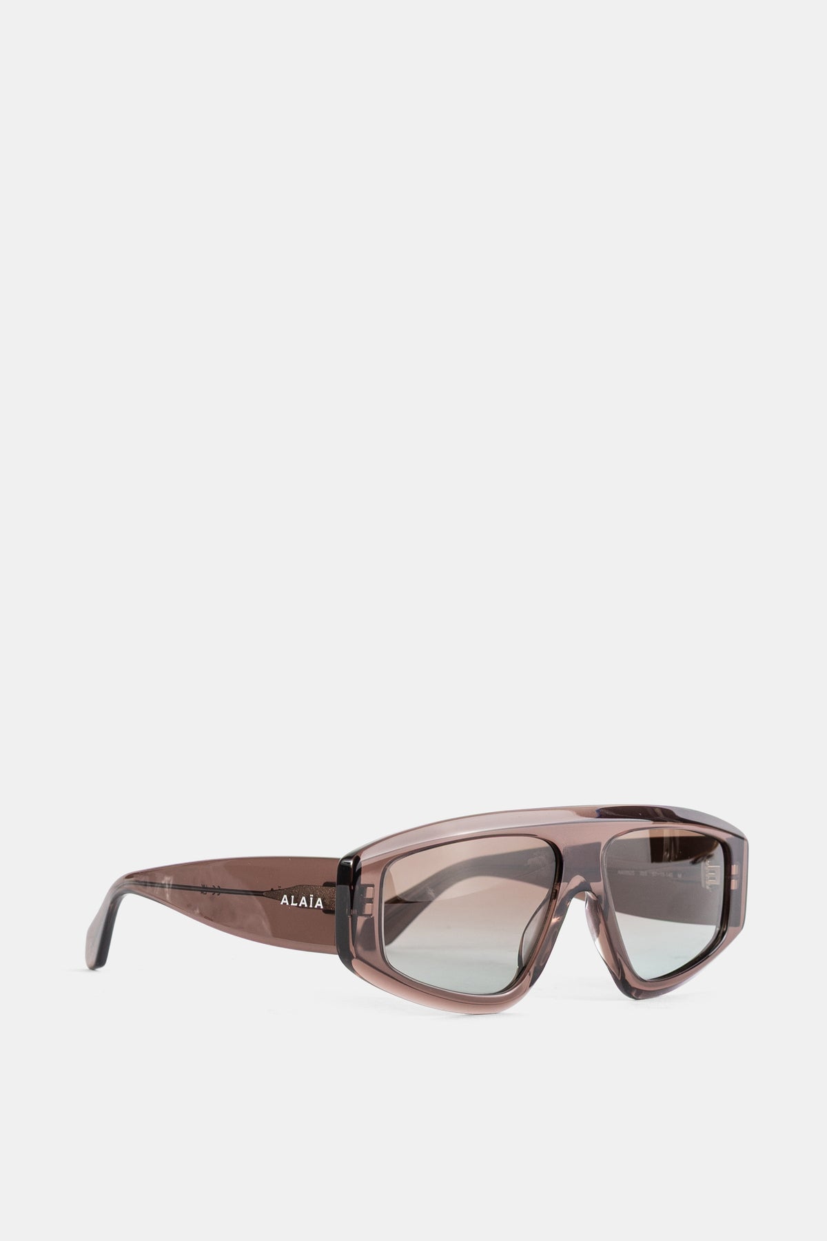 Maison Alaïa lunettes Azzedine vue trois quarts, branches transparentes et logo blanc sur acétate brun