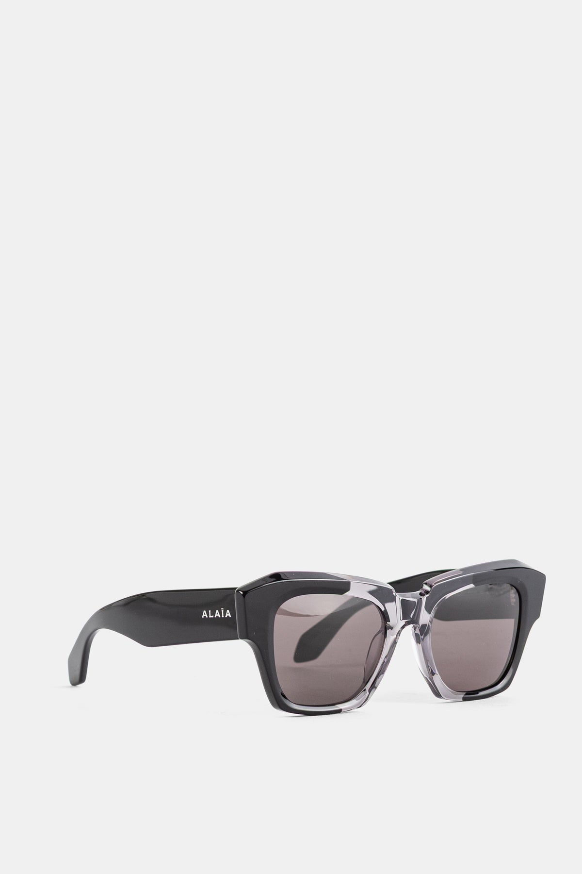 Maison Alaïa vue trois quarts lunettes soleil carrées verres fumés gris monture bicolore acetate FW26