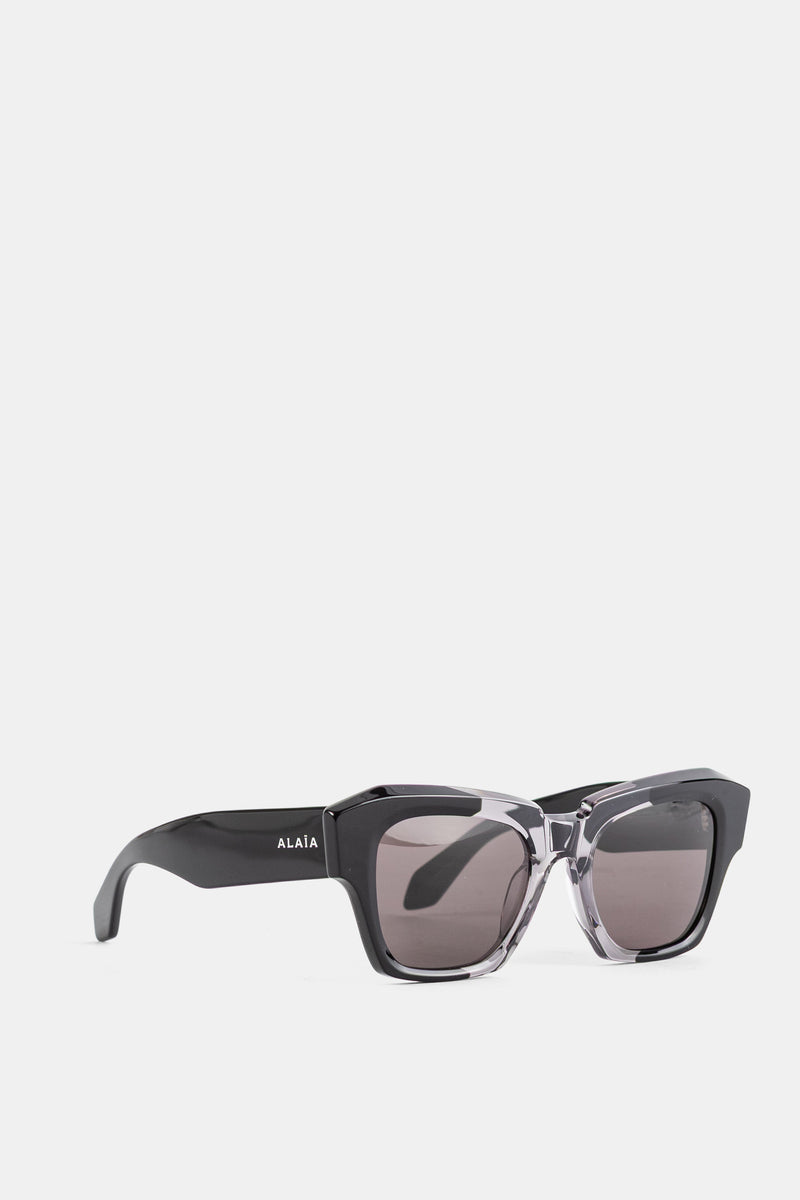 Maison Alaïa vue trois quarts lunettes soleil carrées verres fumés gris monture bicolore acetate FW26