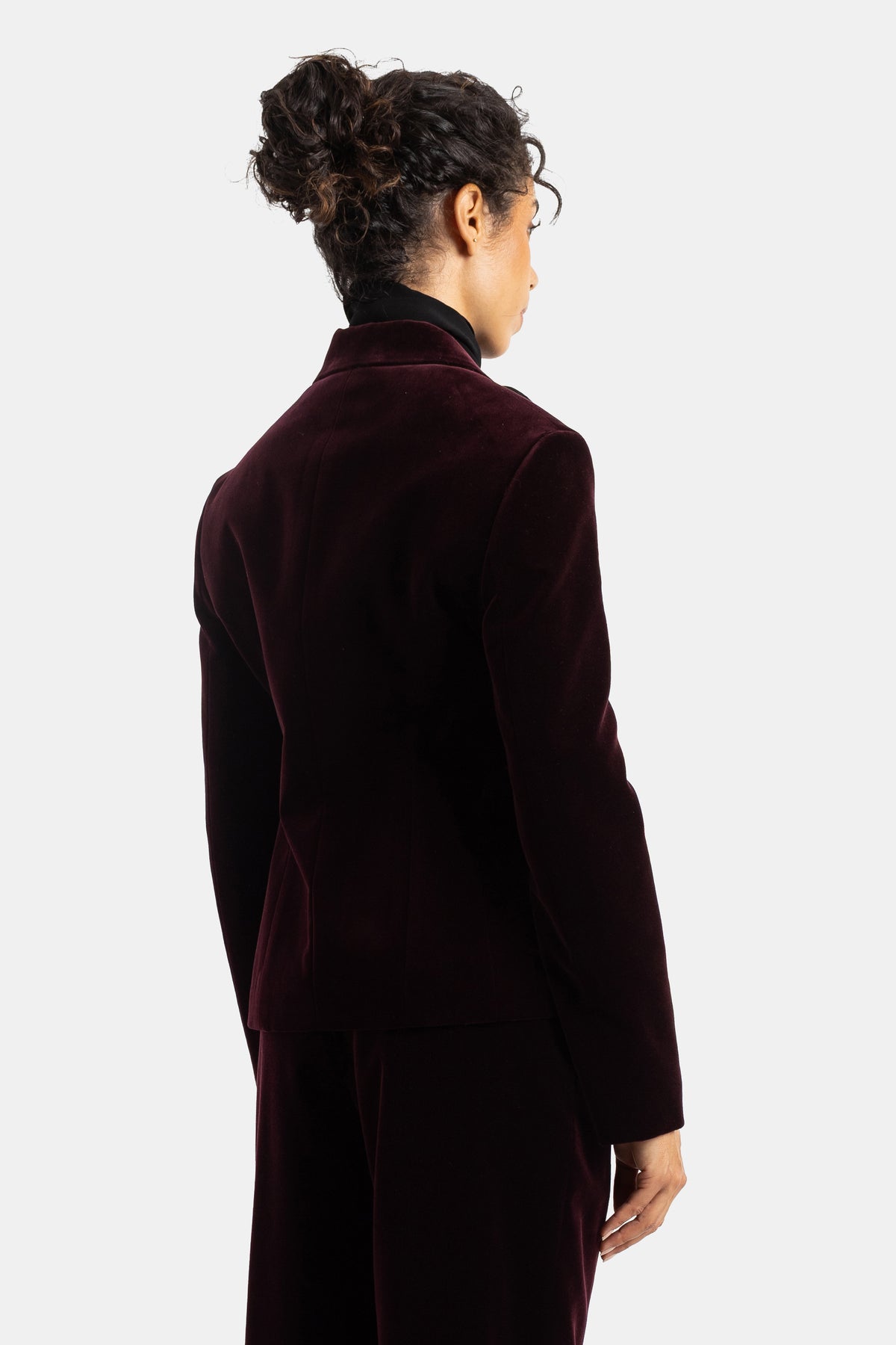 Blazer Maison Alaïa de terciopelo berenjena con espalda entallada, cuello alto negro y corte estructurado