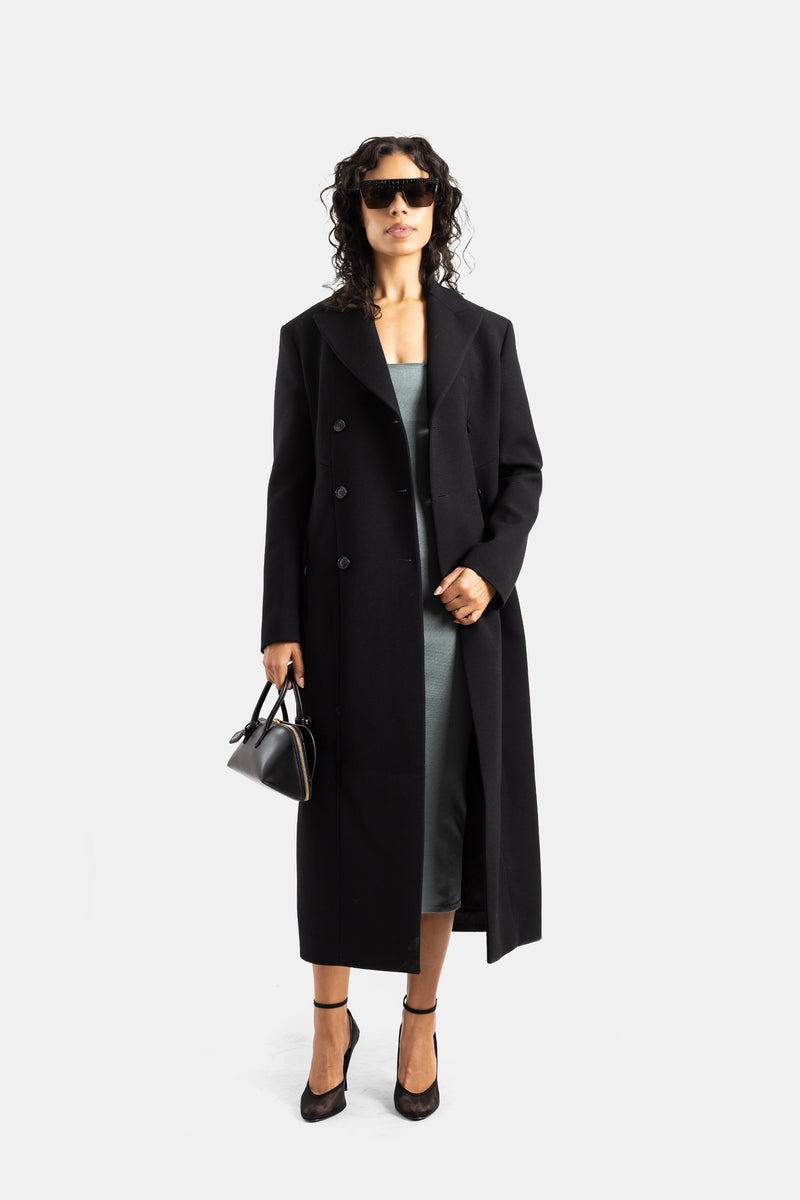 Maison Alaïa cappotto doppiopetto in lana nera indossato aperto su abito grigio e borsa bowling donna