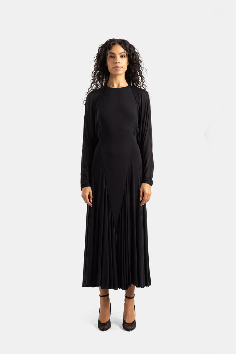 Maison Alaïa long black dress with batwing sleeves, round neck and pleated godet skirt in fluid jersey.