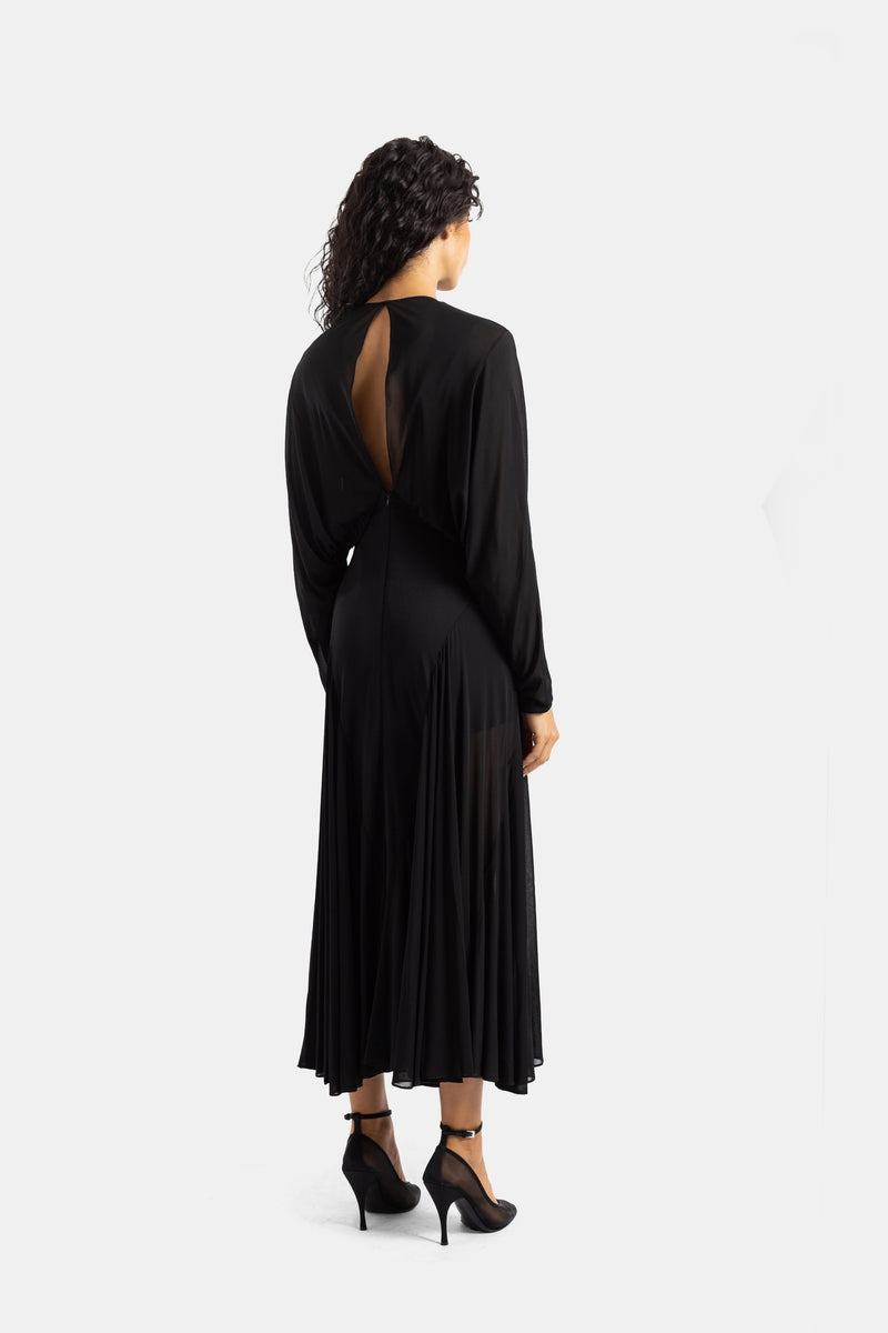 Back view of Maison Alaïa black dress with an open backless design, batwing sleeves and midi godet skirt.