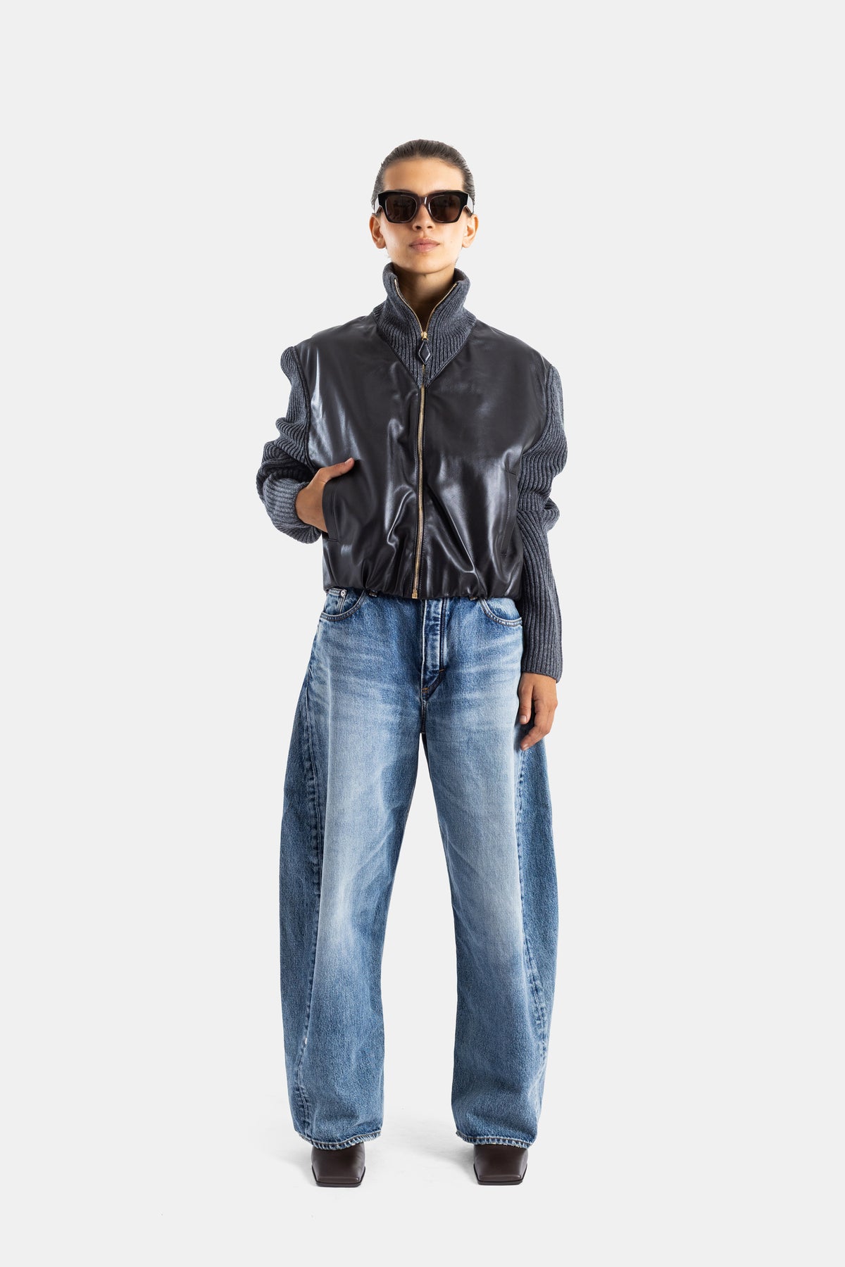 Maison Alaïa jean Rodeo barrel fit denim bleu vintage porté avec veste bomber cuir noir, vue face
