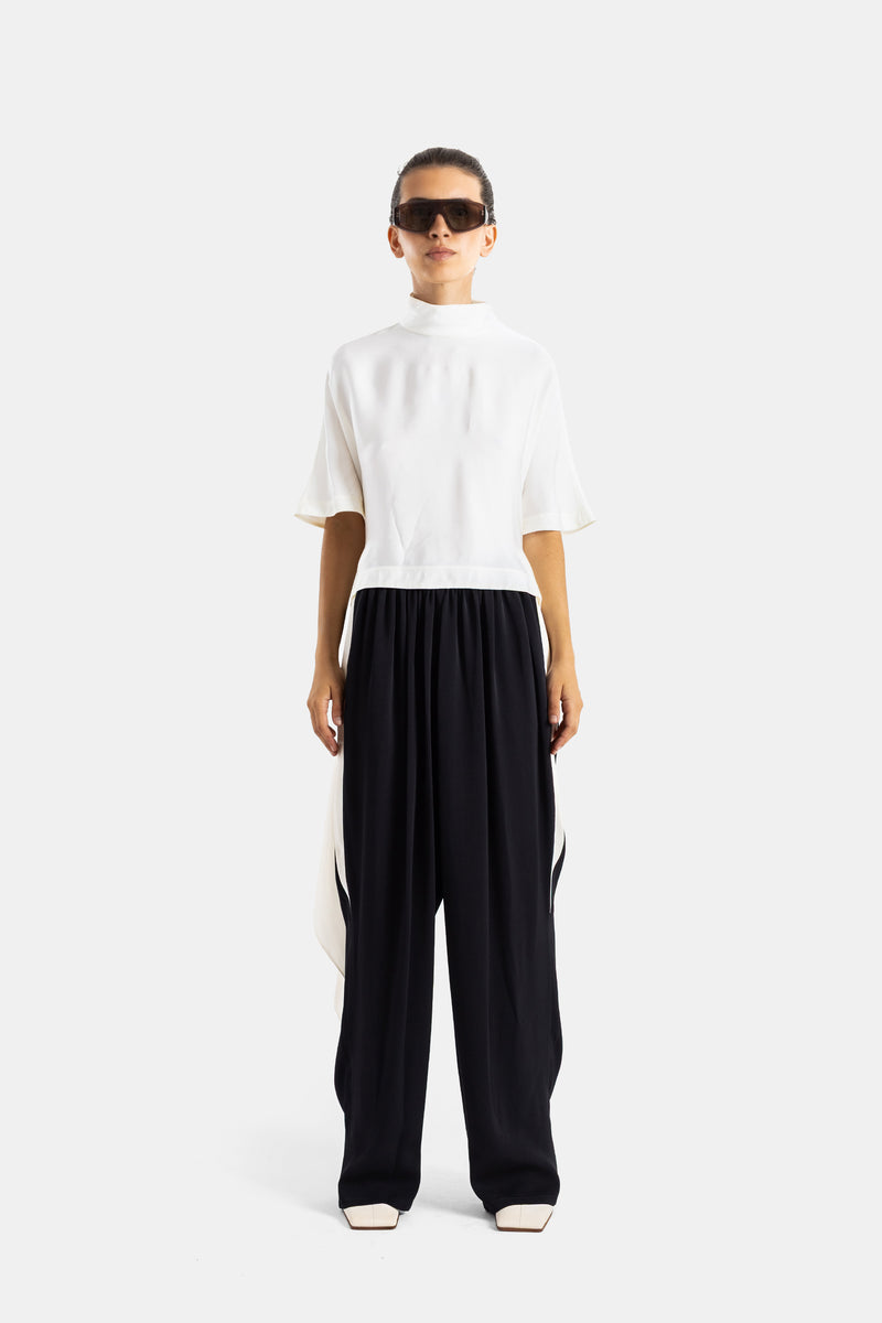 Maison Alaïa top viscose satinée crème porté avec pantalon large noir, silhouette contrastée vue de face