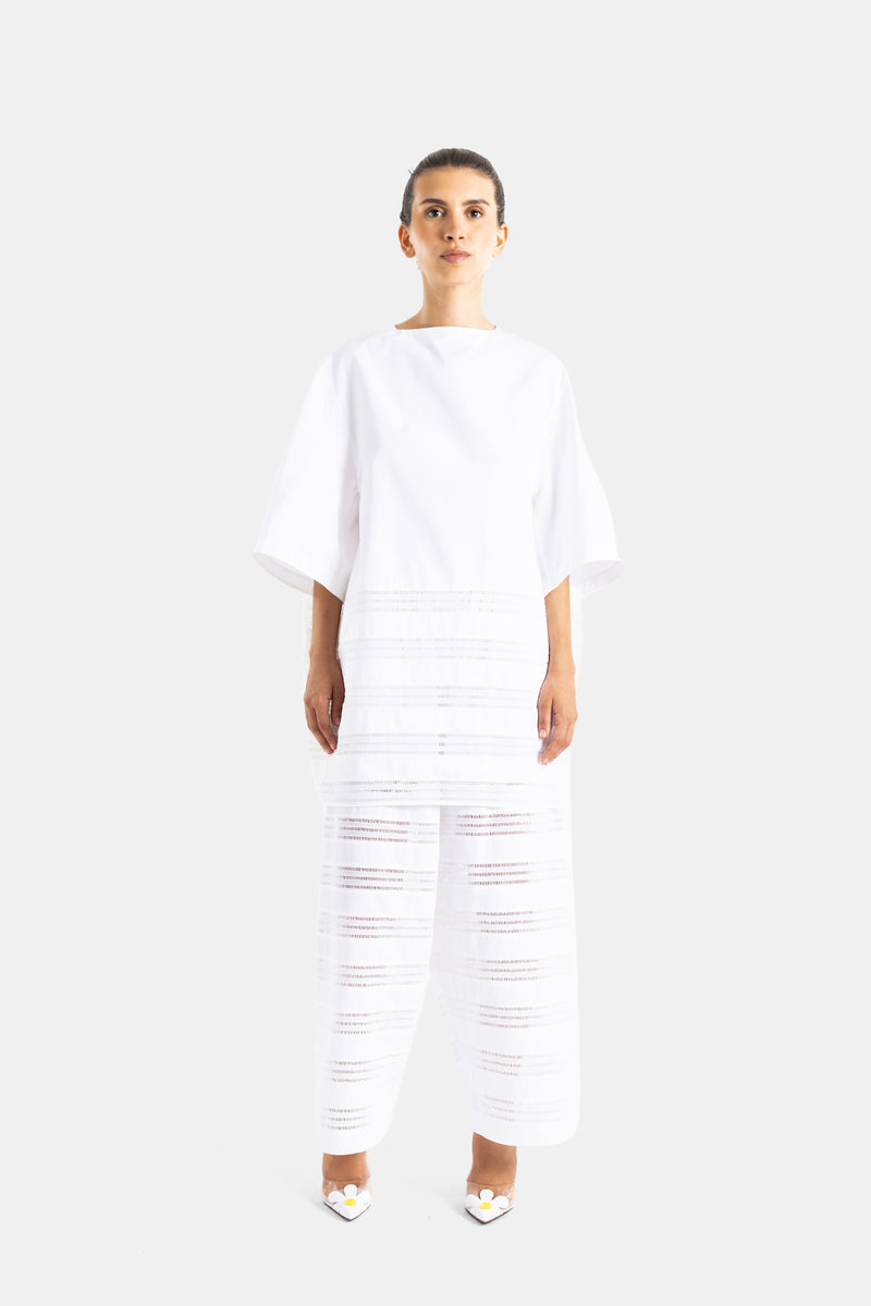 Maison Alaïa ensemble blanc femme robe popeline coton et pantalon ajouré porté avec escarpins fleuris