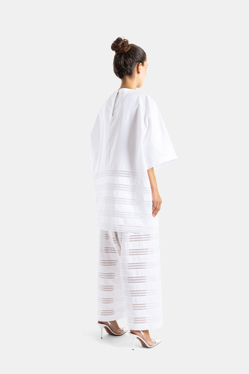 Maison Alaïa robe popeline coton blanc vue dos trois quarts, manches courtes larges et bandes ajourées verticales