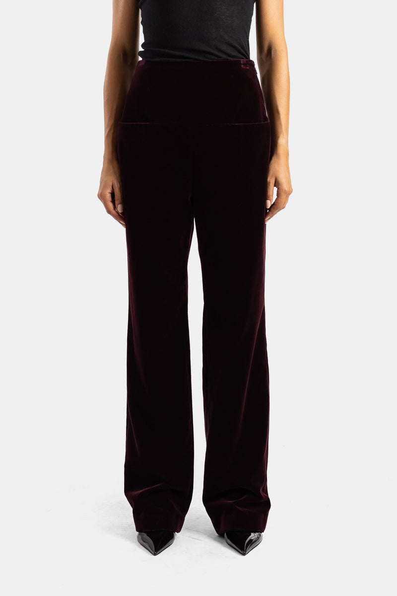 Pantaloni wide-leg a vita alta Maison Alaïa in velluto melanzana, dalla silhouette ampia e caduta setosa.