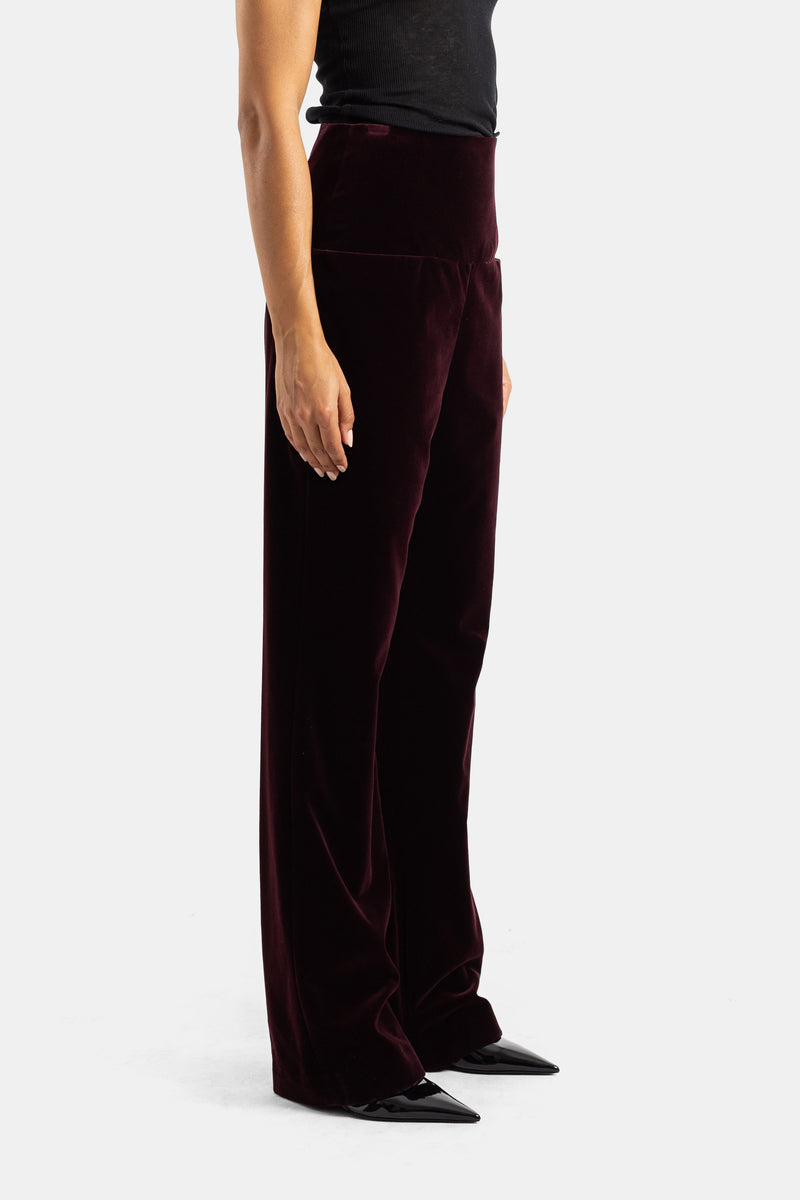 Pantaloni in velluto bordeaux Maison Alaïa vista laterale, taglio dritto fluido e vita alta strutturata