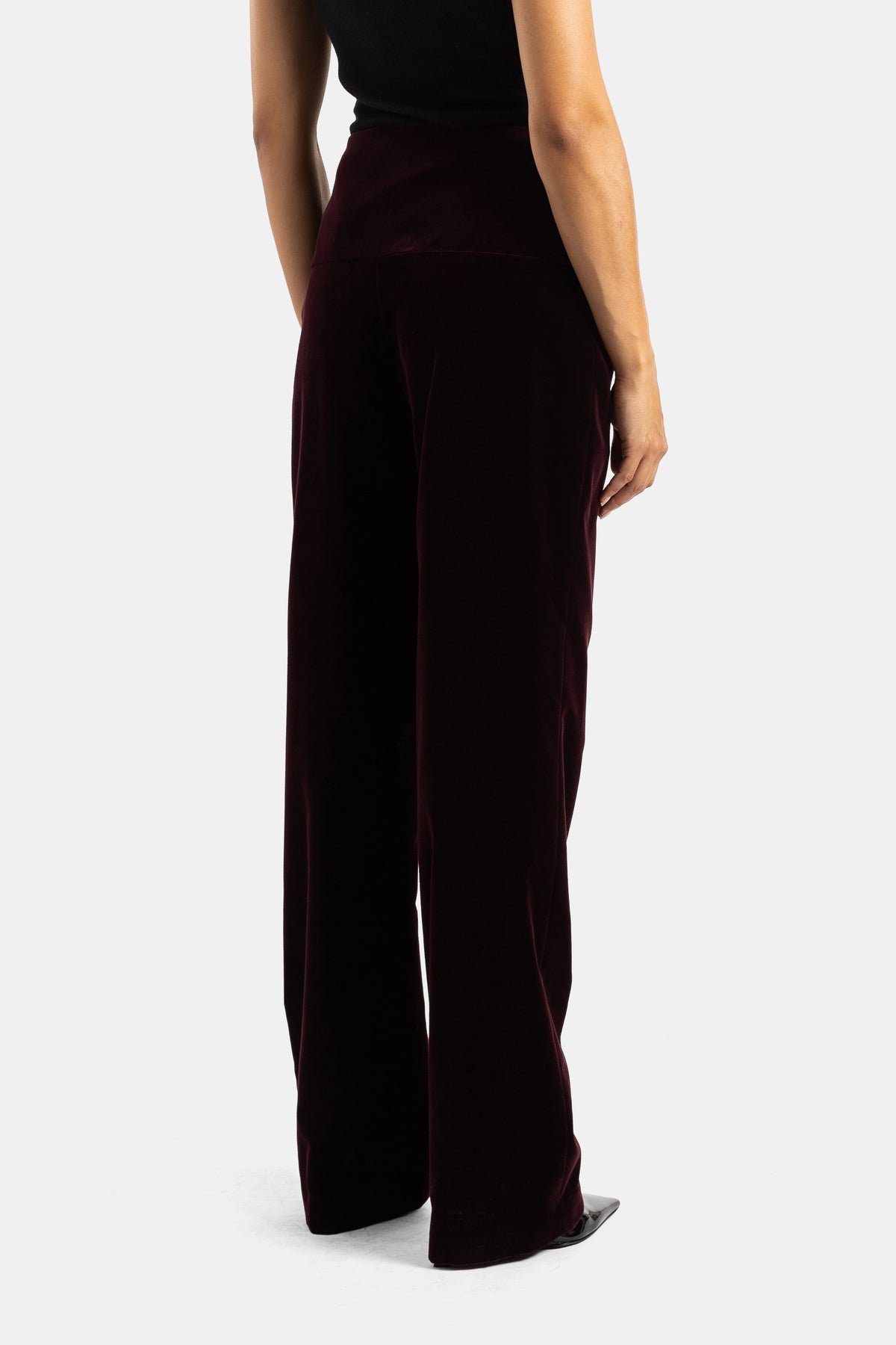 Pantaloni in velluto melanzana Maison Alaïa vista posteriore, vita alta avvolgente e gamba dritta svasata