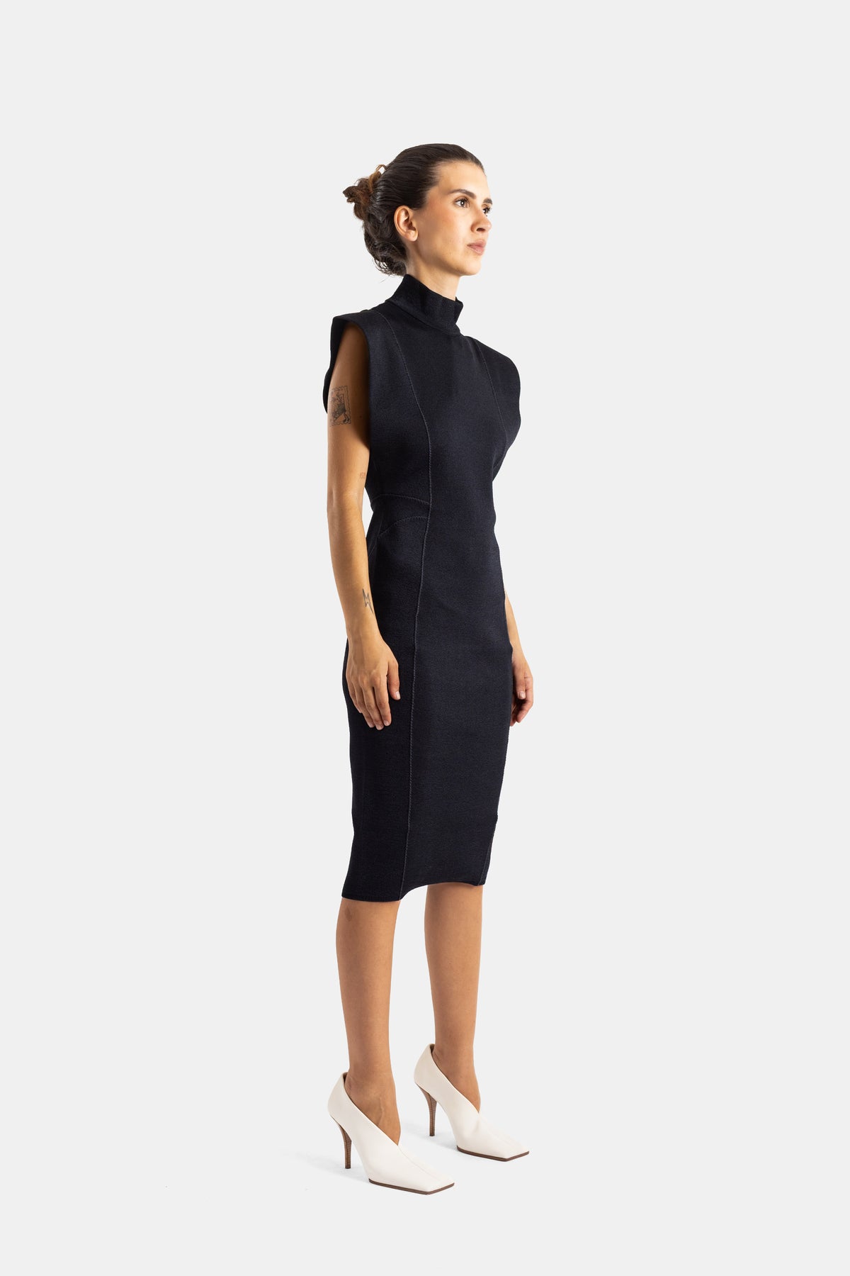 Maison Alaïa robe fourreau noire profil silhouette cintrée coutures apparentes talons blancs
