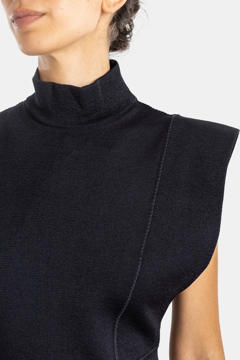 Maison Alaïa robe maille compacte noire col roulé gros plan encolure couture zénithale épaule carrée