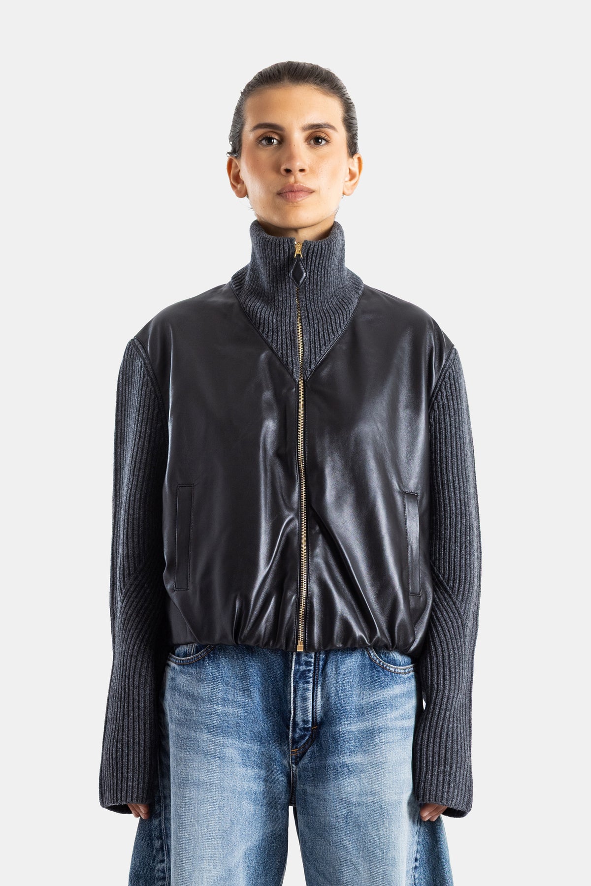 Maison Alaïa veste hybride cuir noir et maille côtelée gris anthracite, col montant zippé doré, manches oversize