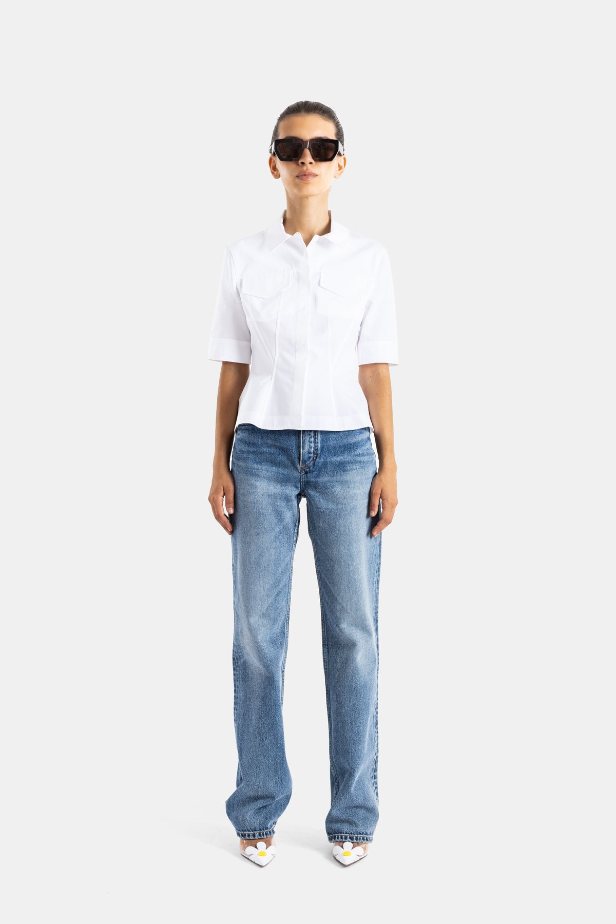 Maison Alaïa top blanc femme porté avec jean droit, poches plaquées et silhouette cintrée