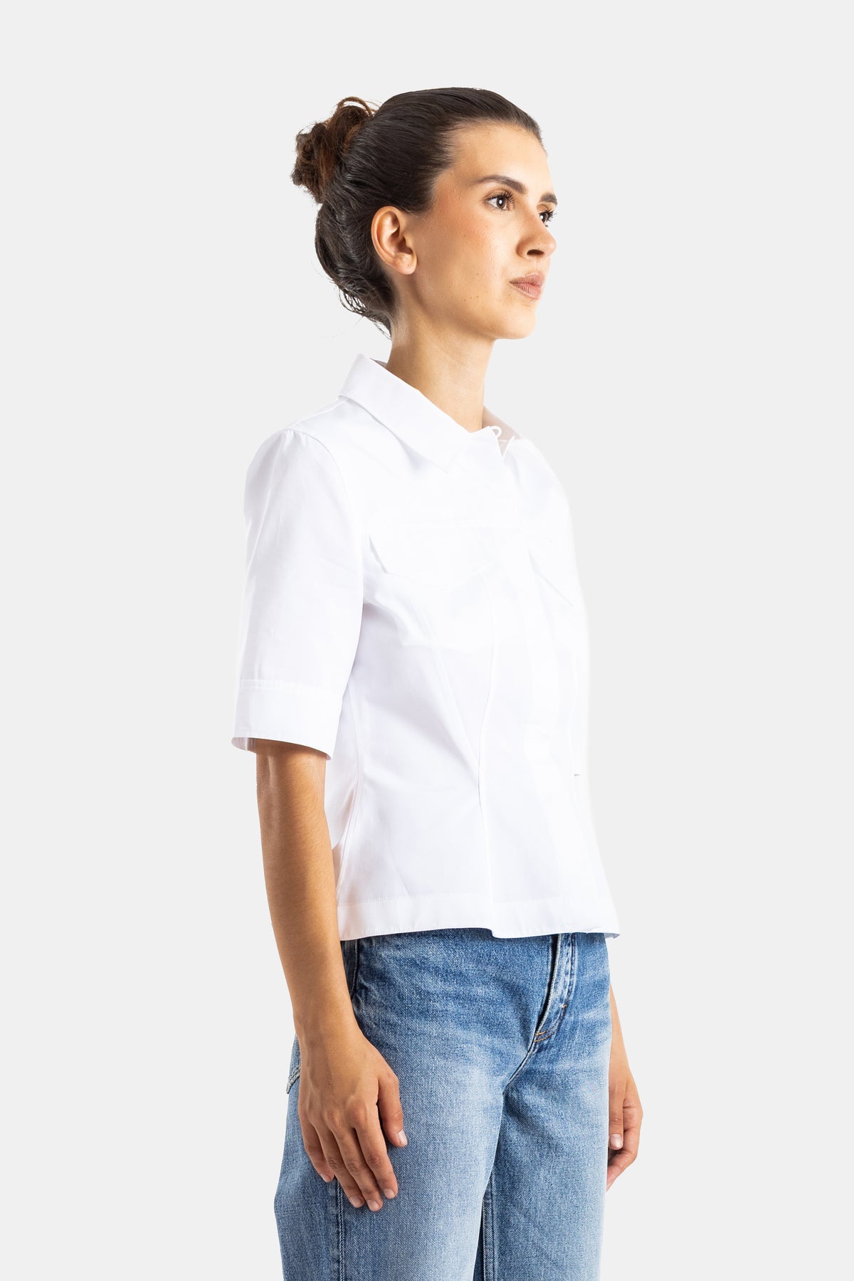 Maison Alaïa chemise blanche femme vue de profil, tissu coton structuré et boutonnage dissimulé