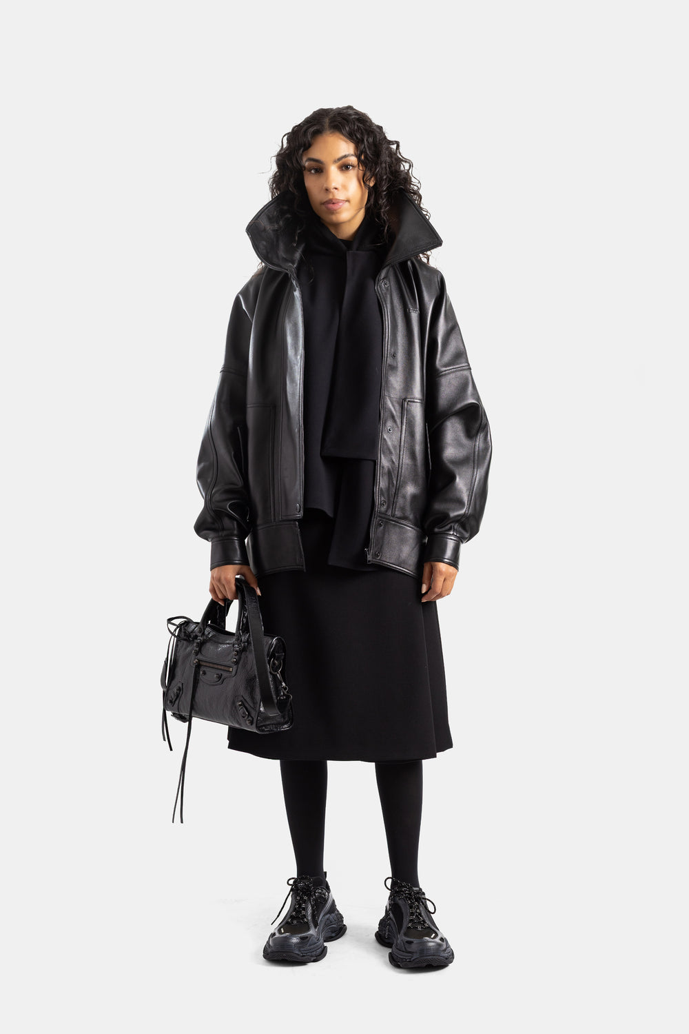 Balenciaga look total black femme blouson cuir oversize sac à main noir sneakers épaisses midi skirt