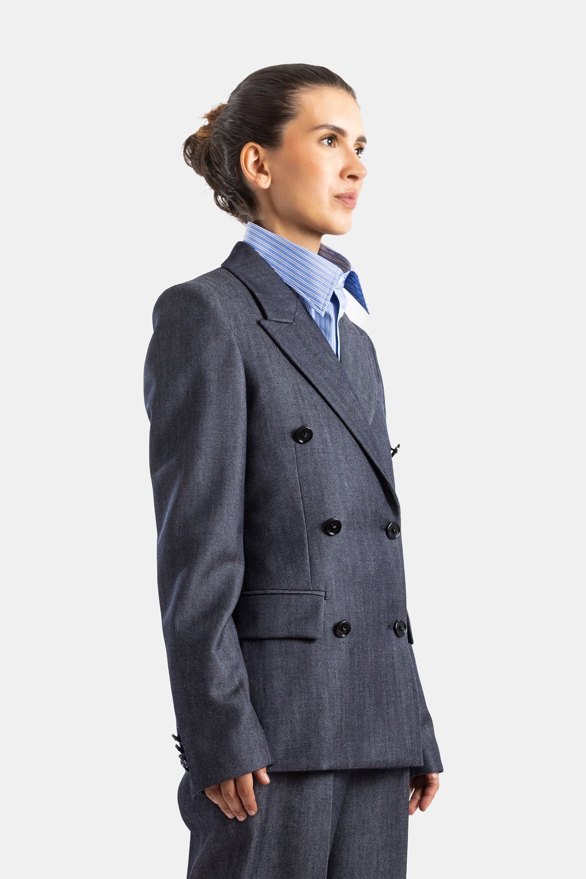 Balenciaga veste denim femme vue de profil, silhouette ajustée, chemise rayée bleue en dessous