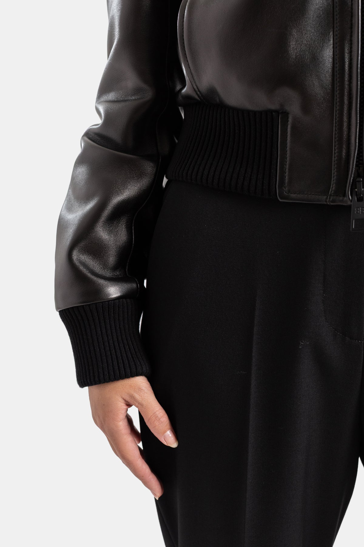 Blusão de pele preto Balenciaga para mulher, detalhe de punho canelado de perfil com corte cintado elegante