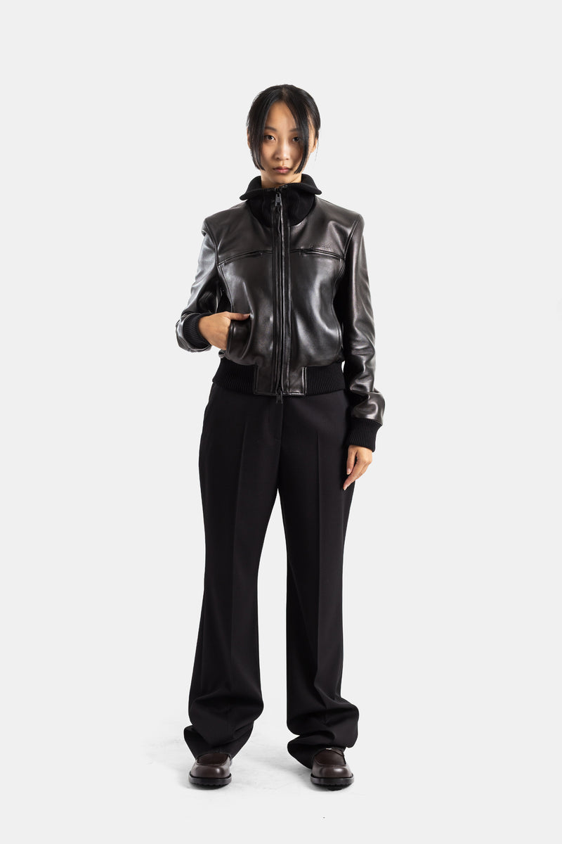 Calças com pinças Balenciaga de mulher com casaco de couro preto, silhueta esguia e corte em lã stretch.