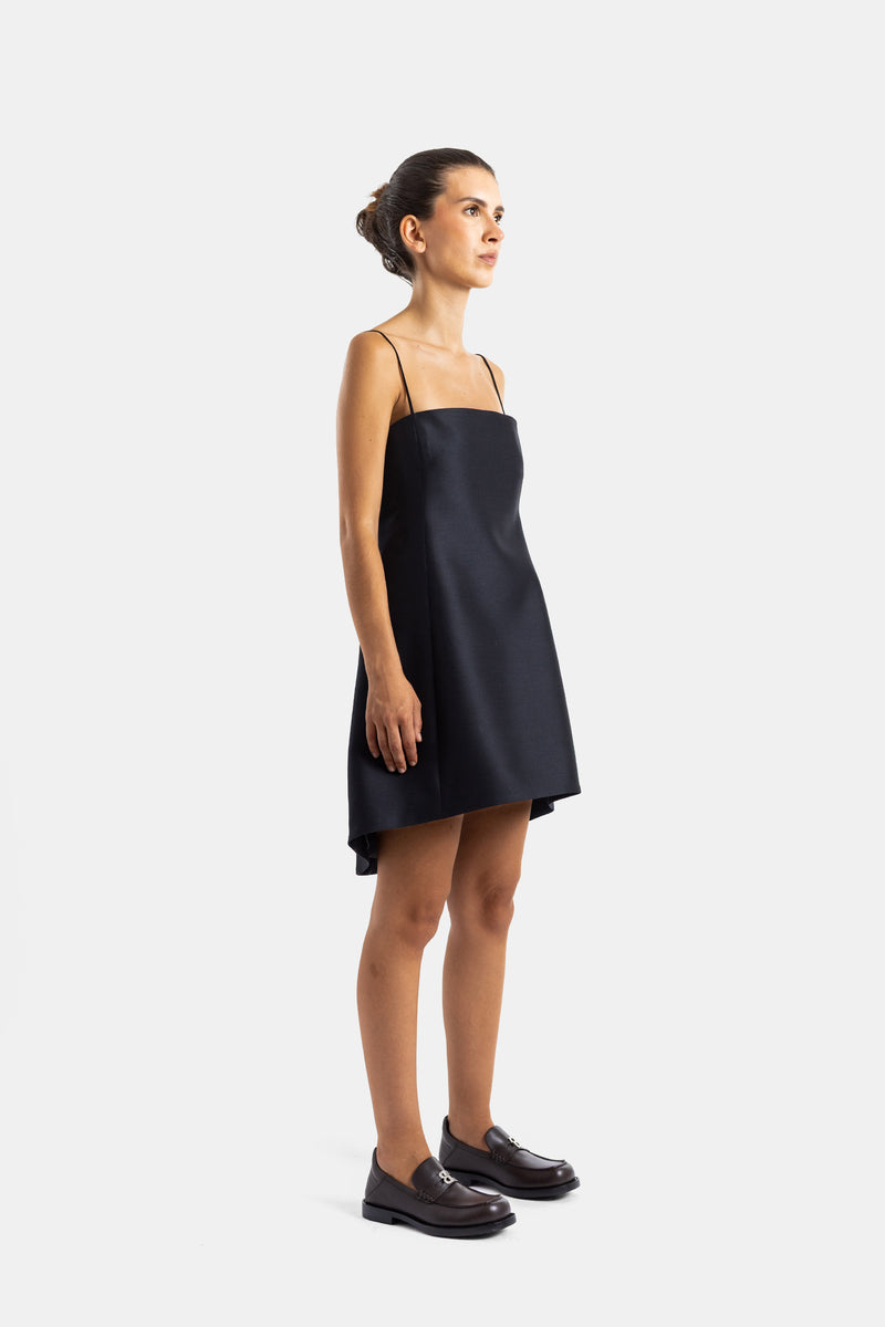 Balenciaga mini robe noire vue de profil, silhouette trapèze, bretelles fines, portée avec mocassins en cuir marron