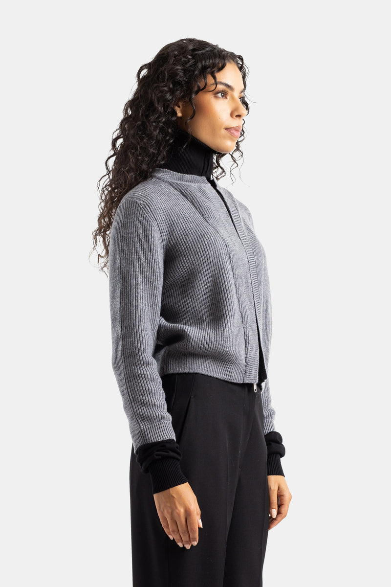 Cardigan donna Balenciaga di profilo in maglia a coste grigia con zip su lupetto nero e maniche lunghe.