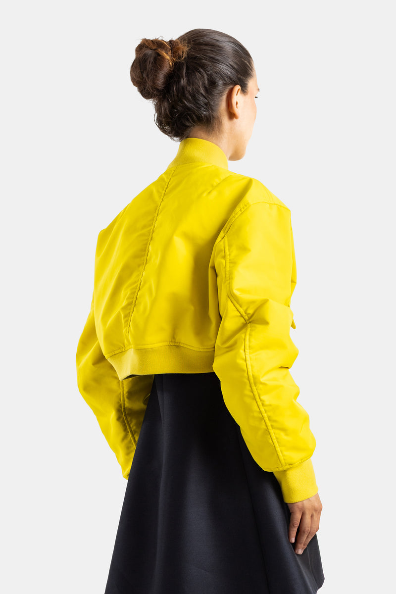 Balenciaga bomber court jaune vue dos, coutures apparentes, bande élastique en bas, porté sur jupe noire