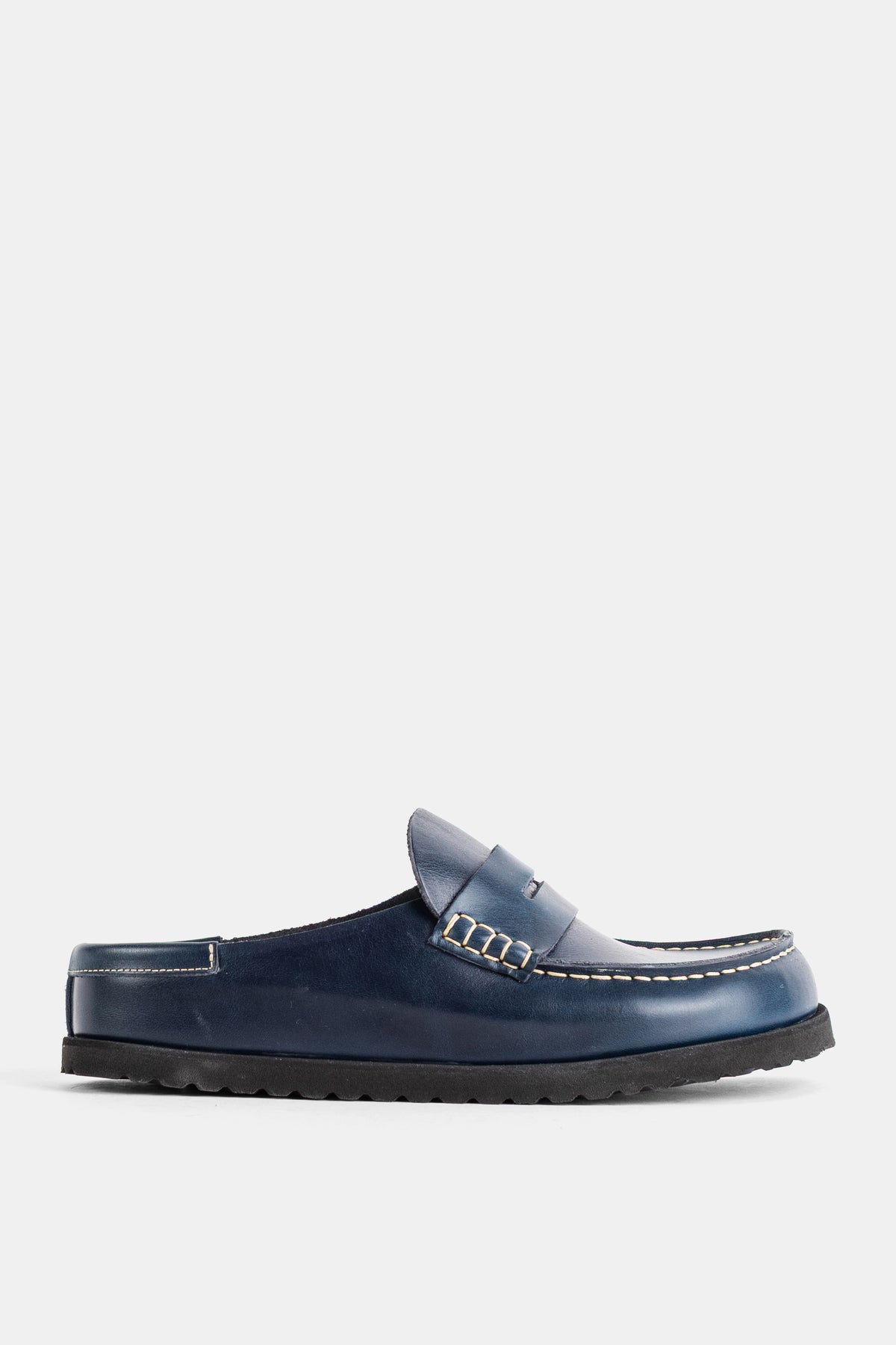 Birkenstock 1774のNaplesネイビーブルーレザーミュール。ブラックのシャークソールとペニーローファー風のサドルストラップが、クラシックでありながらモダンで都会的な足元を演出します。