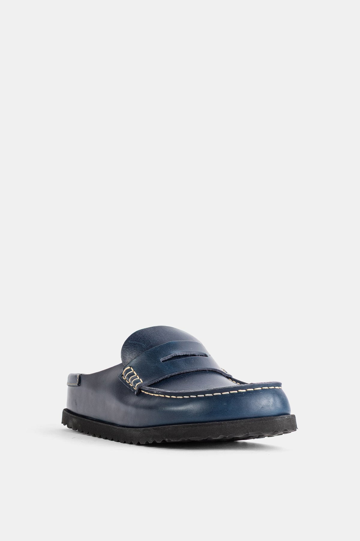 Birkenstock 1774のレディースNaplesミュール。ネイビーブルーレザーに映えるクリーム色のコントラストステッチと、ボリューム感のあるブラックの厚底シャークソールが上品です。
