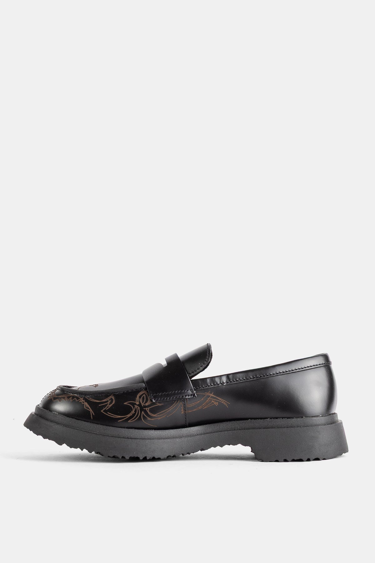 Loafers Walden Camper em perfil lateral esquerdo, pele preta polida, padrões florais castanhos e plataforma de dentes.